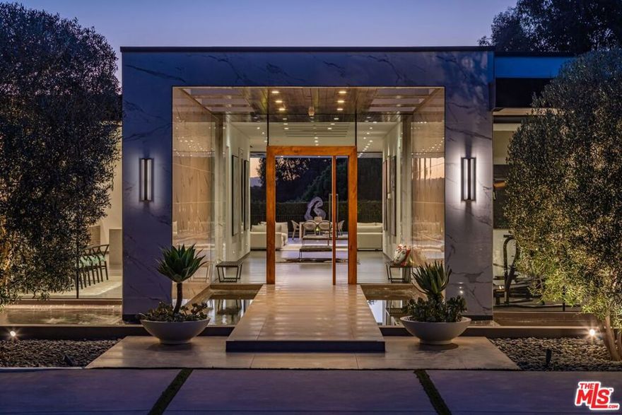 A modern masterpiece on a sprawling 37,000 SF prime lot in the exclusive Trousdale Estates. Tucked away off Loma Vista Drive, behind a gated 200-foot-long gated driveway, this property ensures complete privacy while offering breathtaking canyon views. Once the site of Dean Martin's home, this newly constructed estate, completed in 2017, embodies luxury and glamour. With over 10,000 SF of living space, the estate features 12-foot ceilings and the latest and greatest amenities, including Crestron home automation system. The floating entrance leads to a light-filled gallery-style foyer that is perfect for displaying your art collection. The expansive great room includes a living room, family room, and bar, all enhanced by motorized Fleetwood doors opening to a remarkable outdoor space for seamless indoor/outdoor living. The outdoor oasis features a large patio, fireplace, a pool, an outdoor kitchen with a 48" BBQ range, and lush canyon views. The formal dining room boasts a wine display for 300 bottles, adjacent to a custom kitchen with Miele appliances. The luxurious primary suite offers a fireplace, dual walk-in closets, and a spa-like bathroom. Four additional bedroom suites feature private patios, and amenities include a theater, gym, and spa. With a motor court for 20+ cars and a three-car garage, this estate offers an unparalleled living experience in an exclusive locale. This Trousdale estate represents the pinnacle of luxury living, offering an unmatched blend of privacy, elegance, and breathtaking views in one of Los Angeles' most exclusive neighborhoods.