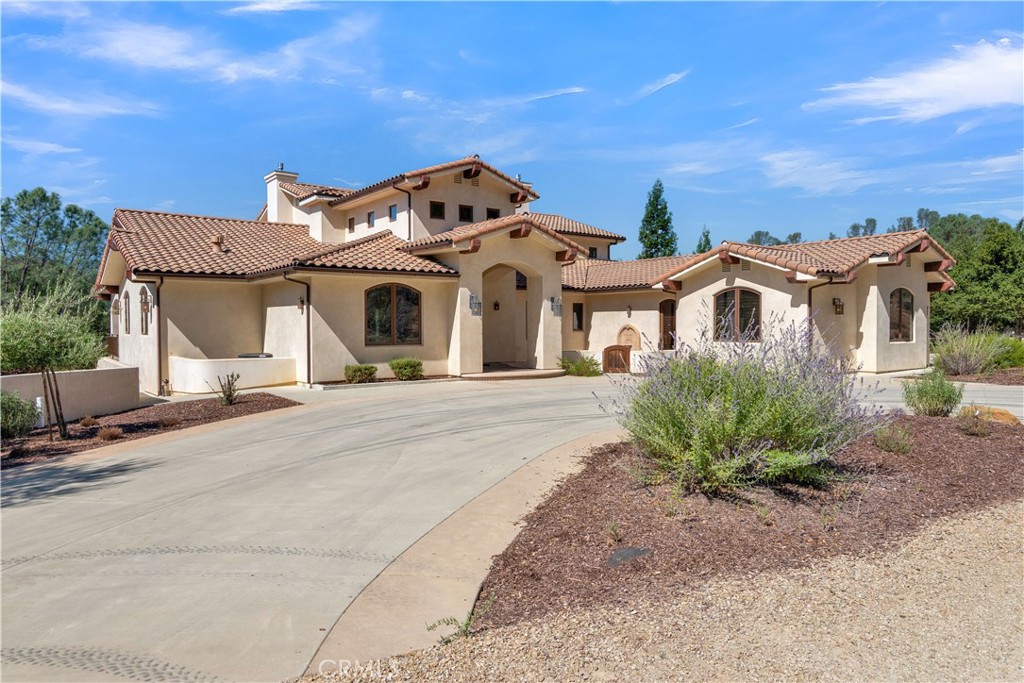 Perched on the highly sought-after Cantinas Point in the gated community of Oak Shores at Lake Nacimiento, this expansive 2+ acre lakefront estate seamlessly blends luxury, comfort, and functionality. With 5 bedrooms, 4 full bathrooms, and 2 half bathrooms, the home is thoughtfully designed for both entertaining and everyday living. The main level welcomes you with a flexible floor plan. An office with built-in storage provides the perfect workspace, while the gourmet kitchen features granite countertops, stainless steel appliances, a walk-in pantry, and utility closet. The breakfast nook connects effortlessly to the formal dining area with a fireplace, flowing into the spacious living room anchored by a second fireplace. French doors open out to a sweeping deck with a complete outdoor kitchen and paver system decking ideal for gatherings with family and friends. This level also includes a half bathroom, three guest bedrooms, a full bathroom, and a fourth bedroom with en-suite bathroom, plus a laundry room and four-car garage. The upper level offers added versatility with a full kitchen, dining area, and living room with French doors opening out to a second outdoor kitchen and deck overlooking the lake. The luxurious primary suite is also upstairs, offering a lake view, a walk-in closet, and spa-like en-suite bathroom with dual vanity, soaking tub, and tiled shower stall with seven shower heads. A climate-controlled stairwell from the main to the lower-level doubles as a wine cellar, and a dumbwaiter services all three floors for convenience. The lower level is designed for recreation and future customization, featuring a spacious game room equipped with a fireplace, plumbing, electricity and a chase for additional cooking options, a full bathroom, and a half bathroom. With built-in soundproofing and spray foam insulation throughout the home, this level also offers the opportunity to add a theater room, bunk room, or extra bedroom. Parking is made easy with the concrete driveway, attached 4 car garage and carport with an outdoor shower and setup to wash off your lake toys. Crafted with attention to detail and modern conveniences throughout, this remarkable property offers the ultimate lakefront lifestyle at Lake Nacimiento.