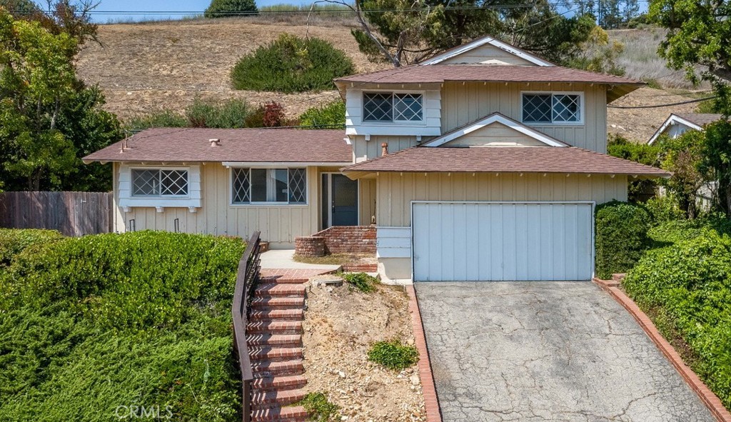 Step out your front door to breathtaking ocean vistas from this home positioned at the entrance of a quiet cul-de-sac. This charming property offers the perfect blend of coastal living and natural privacy, with hiking trails as your backyard neighbor, creating a true retreat atmosphere. The thoughtfully designed layout features a welcoming living room anchored by a cozy fireplace, plus a separate family room providing flexible space for entertaining and relaxation. The kitchen makes daily meal prep a joy with expansive hillside and ocean views that stretch beyond the property, turning routine cooking into moments of inspiration. The dining area is conveniently located next your kitchen. The four bedrooms provide ample space for family and guests, with one conveniently located on the lower level for added flexibility. The generous lot size provides privacy while offering endless possibilities for outdoor enjoyment and recreation. This home is ready for your personal vision and creative touch to unlock its full potential.