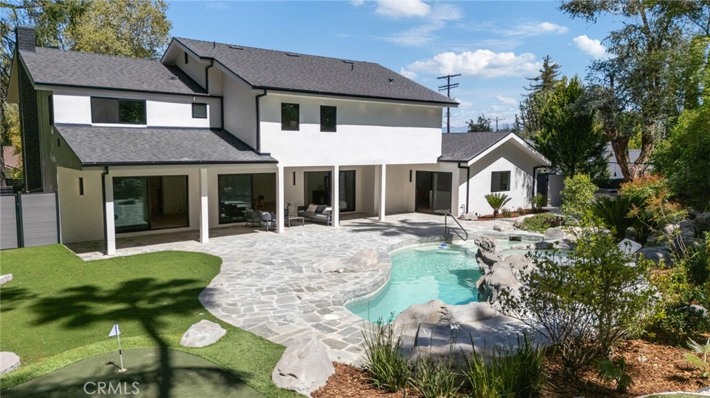 Welcome to 19532 Wells Dr, a private, gated sanctuary set on an expansive 18,000 sq. ft. lot in the heart of Tarzana. This nearly 4,000 sq. ft. home has been beautifully reimagined, blending modern elegance with warm, inviting spaces.
A grand double-height foyer welcomes you, leading into the spacious living and dining areas, both seamlessly extending to the backyard through oversized glass sliding doors—perfect for indoor-outdoor living. The chef’s kitchen is a masterpiece, featuring a large island, a breakfast nook, and top-of-the-line finishes.
Downstairs, a versatile media room (or fifth bedroom) offers its own private bath and closet. Upstairs, the primary suite is a retreat unto itself, with a spacious walk-in closet, private balcony, and a luxurious en-suite bath. Three additional bedrooms complete the second level.
Step outside to your lush, tropical oasis—a flat, resort-style backyard with total privacy, a sparkling pool surrounded by island-inspired landscaping, and a fabulous al fresco dining area with an outdoor kitchen and grill. The property is set back from the street with a gated motor court, adding both security and curb appeal.