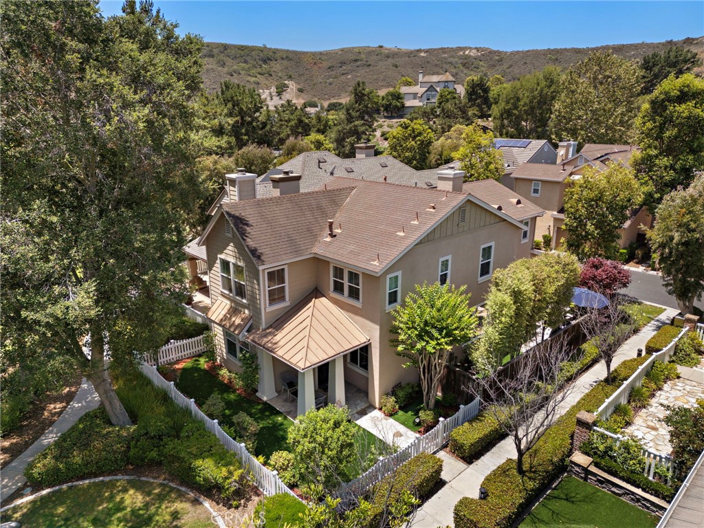 Welcome to this beautifully maintained 4-bedroom, 2.5-bathroom home offering approximately 2,300 sq ft of living space, nestled at the end of a peaceful cul-de-sac. This ideal location provides unmatched privacy, a full driveway, and direct access to the scenic Paseo Trail and Butterfly Park. From the moment you arrive, you’ll be greeted by charming curb appeal, featuring a classic white picket fence, updated hardscape and softscape including lush synthetic turf, stone finished pathway, up-lighting and a well-maintained garden. Inside, enjoy fresh new paint throughout, updated hardwood floors, recessed lighting and thoughtful designer touches like plantation shutters, built-ins and crown molding. The spacious, light-filled floor plan includes a formal sitting room at the entry with a nearby powder room, a generous dining room with a fireplace, and a warm family room perfect for relaxing. The large, open-concept kitchen offers serene views of the greenery and patio and is ideal for entertaining. Upstairs, discover four spacious bedrooms (one bed up currently used as a LOFT), including a luxurious primary suite with a cozy fireplace, peaceful tree-top views, and a beautifully updated en-suite bathroom with new flooring, stone slate counters, newer lighting and a large walk-in closet. Additional upgrades include owned solar, a newer water heater, storage racks, and a sleek epoxy garage floor. Enjoy the lifestyle this location affords — within walking distance to award-winning schools, multiple parks, a community water park, and neighborhood pools. This home truly has it all — comfort, style, privacy, and a prime location. Don’t miss your chance to own this rare gem!