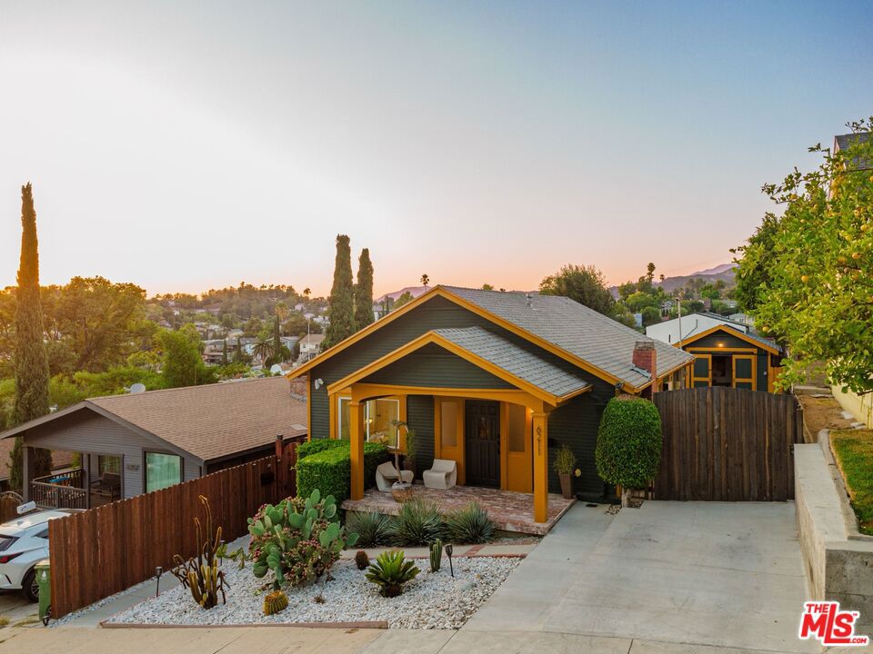 A Highland Park bungalow full of charm and character, paired with a modern, high-producing ADU that offers both a private retreat and strong income potential. Together, they create a property that blends classic warmth with contemporary versatility- ideal for family, guests, or as a thriving Airbnb. Out front, a cactus garden catches the light, while the porch offers a quiet vantage point to watch the day unfold. Inside, the living room glows with natural light, flowing into a dining area made for both everyday meals and evenings that linger. Two bedrooms, connected by an updated Jack-and-Jill bathroom, hold the simplicity of comfort. The kitchen, spacious and refreshed, anchors the back of the home, with a discreet laundry nook. A bonus area extends beyond- a lounge, a den, or a corner to create. A wide back porch gathers the day's light, offering a serene spot to relax and enjoy the outdoors. Down the drive, the detached garage, dressed in barn-style doors, has been reimagined as an office, though its potential remains wide open. At the rear of the property, the fully permitted ADU, completed in 2022, feels like a place apart, a modern sanctuary defined by clean lines and abundant light. Floor-to-ceiling glass opens to the deck, pool, hot tub, and city views, dissolving the boundary between indoors and out, while shades offer moments of quiet retreat. A skylight carries the sky overhead, illuminating a space where design is simple, open, and thoughtful. A kitchenette, bathroom, and living area that move with calm efficiency, gently separating living and sleeping spaces. Around the back, its own designated washer and dryer, making this standalone unit wholly self-sufficient. With its own private entrance leading to the pool and hot tub, the ADU is both a serene retreat and a vibrant hub. Previously operated as an Airbnb, it has generated roughly $75,000 annually, blending effortless lifestyle enjoyment with strong investment potential. Adding to its appeal, the home is powered by Tesla solar panels and Powerwall, pairing modern efficiency with sustainable living. Situated just a short distance from the lively York and Figueroa Boulevards in Highland Park, with their cafes, shops, and nightlife, and within easy reach of Eagle Rock's amenities and charm.