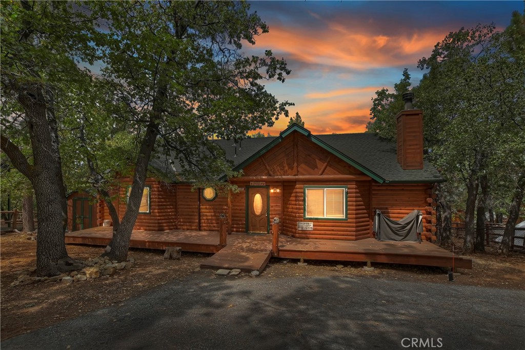 WELCOME TO GRIZZLY GETAWAY, WHERE THIS SINGLE-STORY LOG-STYLE HOME IS SET BACK IN THE OAK AND PINE TREES GIVING IT A PRIVATE & SECLUDED SETTING IN DESIRABLE MOONRIDGE ~ As you step into the living room, you'll love the open concept with vaulted T&G ceilings, log accents and wainscoting giving it a nice rustic feel ~ The cozy corner river rock fireplace is perfect for gathering with loved ones or curling up with a good book ~ Spacious kitchen, featuring knotty pine cabinetry, granite slab counter tops, a custom wood carving and convenient nook easy for dining/entertaining ~ Large primary bedroom with wainscoting and attached bathroom ~ Slate flooring in kitchen and bathrooms ~ Side by side laundry in hallway ~ Step outside and take in the fresh mountain air on either the back deck where you can soak in the hot tub after a day on the slopes or on the front deck around the towering trees ~ Level entry with good sun exposure for parking ~ Enclosed back yard for dog run ~ Storage shed ~ Ideal location near hiking trails, ski resorts, the zoo, and more, making it the perfect getaway for outdoor enthusiasts! Excellent rental opportunity or mountain escape!