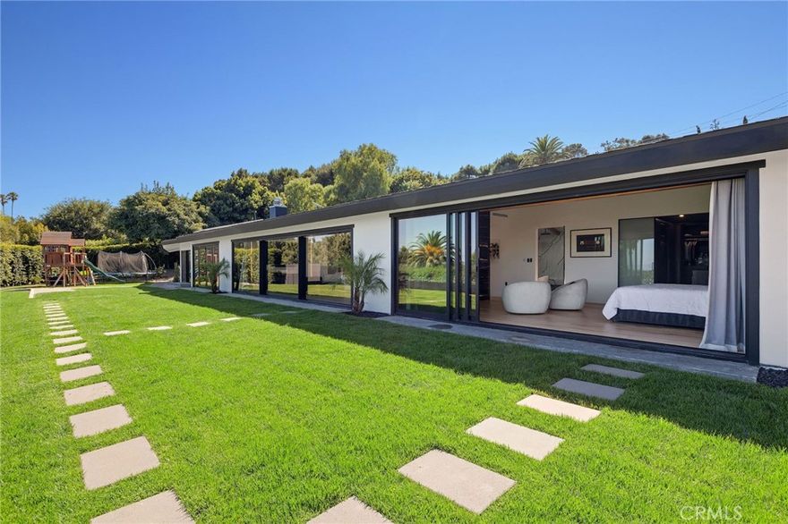 See the 360 Tour: https://bit.ly/3JMU10X** Clean-lined, single-story ranch home with detached 540 sqft ADU—fully renovated—set behind a private gated drive with sweeping harbor, city and ocean views from nearly every room and the expansive grassy backyard. Renovation focused on quality systems and materials: new electrical, HVAC, plumbing, Milgard/Western windows, Tesla solar panels & 2 EV chargers.



Enjoy the Long Beach skyline and LA Harbor as you enter through the oversized glass pivot door into an open floor plan designed for living and entertaining. The chef’s kitchen features black-and-white Dalmatian marble, Rohl fixtures, a large island and a suite of Viking appliances: 6-burner range, double ovens, counter-depth refrigerator and dual dishwashers. Wide-plank hardwood runs throughout; floor-to-ceiling sliders and bifold doors connect the interior with the backyard. A two-way glass fireplace anchors the great room; motorized curtains, recessed LED lighting and built-in AV are integrated.



Additional features include a stylish powder room and large pantry/laundry with two Samsung washer/dryer sets and a utility sink.



Two bedroom wings offer privacy and flexibility. The primary suite enjoys harbor views, fireplace, vaulted ceiling beams, dual showers, spa bath with marble tub and quartz counters, electric skylight, and a custom walk-in dressing room. The secondary wing has four bedrooms (or office/gym), including one suite with walk-in closet and 3/4 bath, plus an oversized hall bath with rose-gold fixtures. Outdoors, a rose garden and mature avocado tree complement the yard.



The detached ADU (permits pending) includes bedroom, kitchen/dining and mini-split HVAC—perfect for guests, rental or multigenerational use. Parking for six, two EV chargers, and over a half-acre lot with professional pool plans included make this home ready for modern living.



Modern finishes, turnkey systems and panoramic views create a rare opportunity in Rancho Palos Verdes’ Miraleste neighborhood.