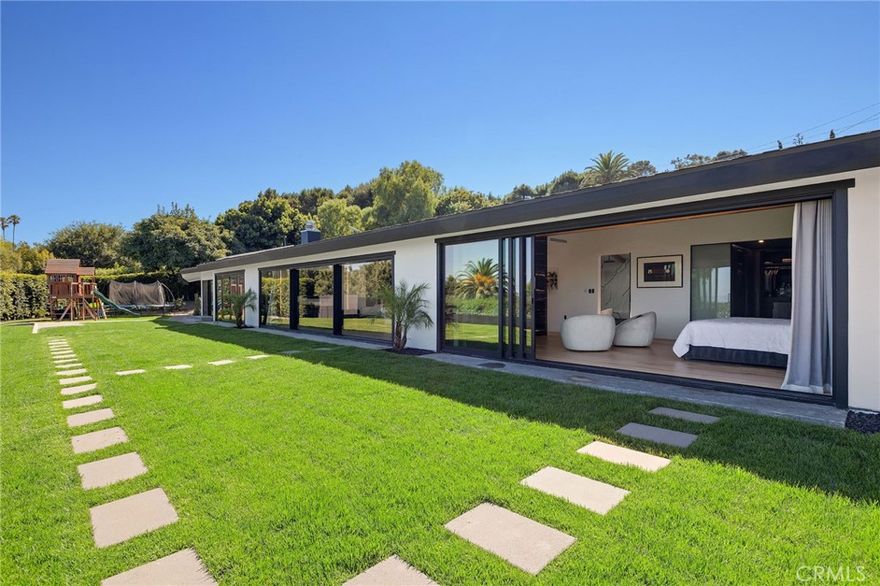 See the 360 Tour: https://bit.ly/3JMU10X** Clean-lined, single-story ranch home with detached 540 sqft ADU—fully renovated—set behind a private gated drive with sweeping harbor, city and ocean views from nearly every room and the expansive grassy backyard. Renovation focused on quality systems and materials: new electrical, HVAC, plumbing, Milgard/Western windows, solar, two backup batteries and EV charging.



Enjoy the Long Beach skyline and LA Harbor as you enter through the oversized glass pivot door into an open floor plan designed for living and entertaining. The chef’s kitchen features black-and-white Dalmatian marble, Rohl fixtures, a large island and a suite of Viking appliances: 6-burner range, double ovens, counter-depth refrigerator and dual dishwashers. Wide-plank hardwood runs throughout; floor-to-ceiling sliders and bifold doors connect the interior with the backyard. A two-way glass fireplace anchors the great room; motorized curtains, recessed LED lighting and built-in AV are integrated.



Additional features include a stylish powder room and large pantry/laundry with two Samsung washer/dryer sets and a utility sink.



Two bedroom wings offer privacy and flexibility. The primary suite enjoys harbor views, fireplace, vaulted ceiling beams, dual showers, spa bath with marble tub and quartz counters, electric skylight, and a custom walk-in dressing room. The secondary wing has four bedrooms (or office/gym), including one suite with walk-in closet and 3/4 bath, plus an oversized hall bath with rose-gold fixtures. Outdoors, a rose garden and mature avocado tree complement the yard.



The detached ADU (permits pending) includes bedroom, kitchen/dining and mini-split HVAC—perfect for guests, rental or multigenerational use. Parking for six, two EV chargers, and over a half-acre lot with professional pool plans included make this home ready for modern living.



Modern finishes, turnkey systems and panoramic views create a rare opportunity in Rancho Palos Verdes’ Miraleste neighborhood.
