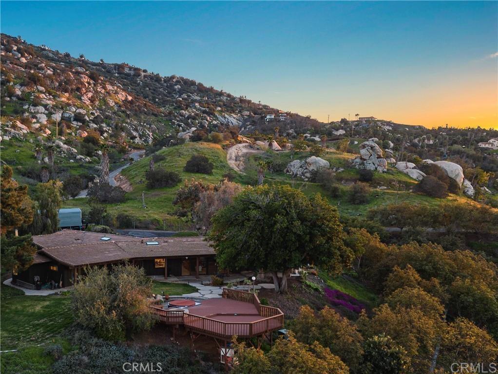 Welcome to Highland Valley Wine Country! Nestled in the rolling hills of Escondido's renowned wine country, this breathtaking 4.5 acre property offers a rare opportunity to own a custom-built adobe home with stunning unmatched panoramic views that stretch across the valley and beyond. Surrounded by over 200 thriving avocado and fruit trees, including graperruit, limes, oranges, persimmons, and mangoes, this property is a dream for those who appreciate privacy, nature, and the potential for hobby farming. The single-story home boasts four spacious bedrooms, two bathrooms, and a dedicated game room/office attached to a three-car garage perfect for a potential in-law suite or guest retreat. Gorgeous wood beam ceilings add character and warmth to the family room, dining area, and game room. The primary suite is privately situated on one side of the home, offering a peaceful escape. Recent upgrades include a new roof, a fully paid-off solar panel system for energy efficiency, and a brand-new AC unit- ensuring comfort and savings for years to come. This property is an entertainer's paradise with endless expansion possibilities-add an ADU, a pool, or a private spa to elevate your lifestyle. Imagine hosting guests while watching stunning sunsets and sparkling night skies from your secluded retreat. Located just steps from Cordiano Winery, you can enjoy world-class wine and dining right in your backyard. Plus, with a new roof and an extensive solar power system, this home is energy-efficient and ready for its next owner. Don't miss this rare opportunity to own a slice of San Diego Wine Country-schedule your private tour today!