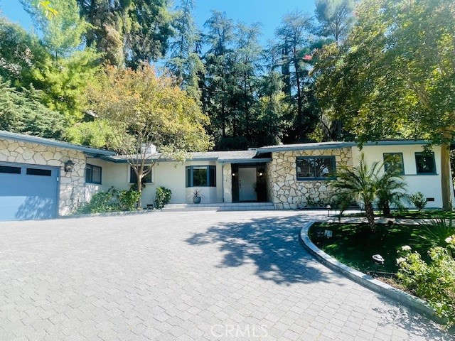 Welcome to this exceptional single-story mini-estate, located in one of Encino’s most coveted neighborhoods, south of Ventura Boulevard. Nestled on a beautifully landscaped and ultra-private 19,572 square foot lot, this mid-century gem blends timeless charm with endless potential.
Spanning approximately 2,300 square feet, the home offers a spacious floor plan featuring 4 bedrooms and 3.5 bathrooms. One of the bedrooms, currently used as a den or office, offers direct access to the backyard and is perfect for remote work, creative pursuits, or a home gym. There is updated flooring throughout the main living areas and bedrooms.The primary suite includes a decorative fireplace and en-suite bathroom.
Soaring beamed ceilings grace the living room with a brick fireplace, which, along with the formal dining room/family room, opens to the lush backyard oasis through sliding glass doors. A charming breakfast nook complements the kitchen, which adjoins an oversized laundry room with additional storage and a convenient half bath.
Step outside and experience resort-style living. The serene backyard features a sparkling pool and cascading waterfall. Towering pines and mature landscaping provide exceptional privacy, while the spacious patio provides for entertaining and relaxation.
Additional amenities include a circular driveway, two-car garage with built-in cabinetry, solar tubes for natural light, an updated electrical panel, newer water heater and dishwasher and with just a few personal touches, this timeless retreat is ready to be reimagined and enjoyed for years to come.
This exceptional property is just moments from shops, restaurants, and the best of Encino.