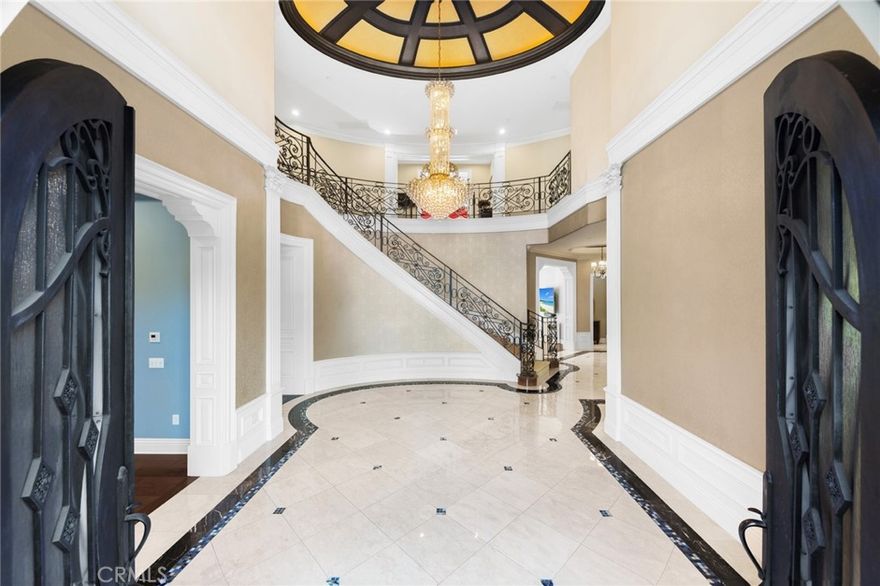 A rare north–south facing custom estate located in the heart of the prestigious Arcadia Unified School District, offering scale, privacy, and versatility ideal for luxury living and multigenerational households.

Beyond grand double iron doors, the home welcomes you with a dramatic two-story foyer featuring elegant marble flooring, a statement crystal chandelier, and a sweeping wrought-iron staircase that sets an immediate tone of refinement.

Designed for both formal entertaining and everyday comfort, the residence includes a formal living room with fireplace, an elegant formal dining room, and a chef’s gourmet kitchen equipped with professional-grade Wolf and Viking appliances, an oversized center island, breakfast nook, and a fully enclosed wok kitchen. A spacious family room, private home office, and exceptional entertainment amenities—including a private home theater and a recreation room with private sauna and full bathroom—offer flexibility rarely found in today’s market.

A desirable main-level bedroom suite provides ideal accommodations for guests or extended family. Upstairs, multiple private suites are anchored by an expansive primary retreat featuring a spa-inspired bath and a private balcony overlooking the grounds.

Outdoors, the resort-style backyard features a swimming pool and private basketball court. Just steps from a neighborhood park and ideally situated within one of Arcadia’s most sought-after school districts, this exceptional estate presents a compelling opportunity for buyers seeking quality, space, and long-term value.