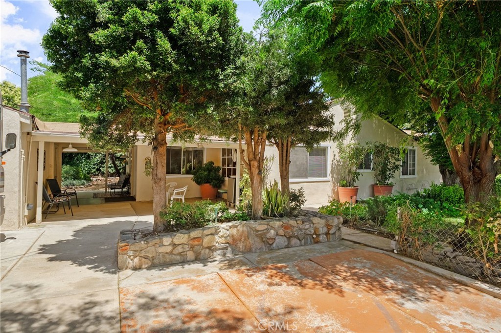 Welcome to this private tranquil home nestled in the serene community of La Sierra Heights - this unique property is a rare gem offering a perfect blend of charm, function, and possibility. Sitting on .37 of an acre, this home features R-3 zoning - potentially allowing multi-unit development and or room for your animals! This home is offered FULLY FURNISHED. Enjoy 3 RV parking spaces, including one with full RV hook-ups. The fully gated property boasts two separate entrances, offering flexibility and privacy. Bonus Room is ideal for a potential bedroom, office, or creative space. Freshly painted inside and out with new carpet making this home exude warmth and charm from the moment you arrive. Explore the multiple lush garden spaces inviting you to natural beauty that radiates peace with mature trees creating a shaded canopy, water fountain, and functioning outhouse. On the property you will find 3 sheds, a dedicated garden space with raised beds ideal for growing what your heart desires, and a fenced in area perfect for securing pets. Here you have convenience located between 91 frwy and minutes from “Horsetown USA” Norco - 15 frwy, La Sierra University, outdoor adventures such as hiking, horse and bike trails near the Santa Ana River Bottom, and Hidden Valley Wildlife Life Area. Whether you’re looking to grow, garden, entertain, or expand - this property offers the flexibly you have been dreaming of - schedule a private tour today!