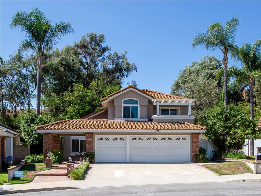 Soaring high ceilings as you enter this 4 bedroom/3 bath home. Great location on a quiet street in a well maintained neighborhood. French doors from the formal dining lead to a back patio area. Desirable downstairs bedroom with easy access to a full bathroom. Wood flooring has been installed in the family room and downstairs bedroom. Master suite features high ceilings, private balcony/deck with views, ceiling fan & large private bath w/walk in closet. Secondary bedrooms are nicely sized & one enjoys a small private balcony. Upstairs hallway features custom display cabinetry to showcase collectibles. Backyard is fantastic for entertaining. Good sized grass area as well. 3 car garage. Convenient indoor laundry room.