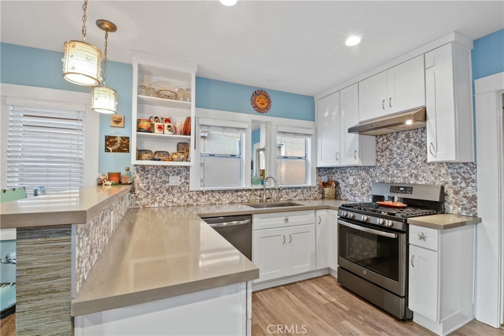 Welcome to 2604 S Kerckhoff Avenue, a charming single-level residence nestled in the heart of San Pedro’s highly sought-after Point Fermin neighborhood. This thoughtfully updated home blends classic coastal character with modern comfort, creating an inviting retreat just moments from the ocean. Behind the gated front yard framed by low maintenance desert landscaping, a shaded front porch offers the perfect spot to unwind and enjoy the coastal breeze. Step inside to a bright and open living room that seamlessly connects to a beautifully remodeled, light-filled kitchen. Designed with both style and function in mind, the kitchen showcases sleek quartz countertops, contemporary white and gray tile backsplash, white cabinetry with silver accents, and stainless-steel appliances, including a freestanding range, refrigerator, and dishwasher. With ample cabinetry, breakfast bar seating, and a convenient stackable washer and dryer, this space is perfect for everyday living and effortless entertaining. Proceed into the cozy bedroom with its own ensuite full bathroom, also ideal for guests, a home office, or a flexible bonus space. The expansive primary suite offers a true retreat, complete with a spacious sitting area, remodeled ¾ bathroom with modern finishes, a generous walk-in closet, and sliding glass doors opening directly to the backyard. Out back, enjoy a low-maintenance oasis with paved surfaces, desert landscaping, and a deck adorned with string lights, an ideal setting for evening gatherings or relaxing under the stars. Notable upgrades include a newer roof, exterior paint, a remodeled kitchen and primary bathroom, and upgraded electrical in the living room and kitchen to 100 amps. Whether you’re a first-time buyer, downsizing, or simply looking for a San Pedro home that offers a balance of modern updates and timeless charm, 2604 S Kerckhoff Avenue is ready to welcome you home. With the exciting upcoming West Harbor waterfront development just minutes away, featuring world-class dining, sweeping ocean and port views, live entertainment, and recreation, this location offers the best of coastal living and vibrant community growth right at your doorstep.