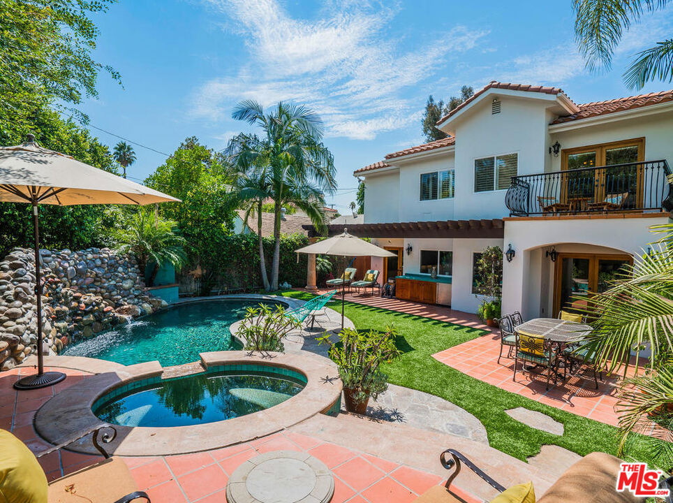 Stunning Mediterranean Retreat!Over six figures in upgrades, inside and out, elevate this 5 bed / 4.5 bath, 3,532 sq. ft. home, showcasing Brazilian cherry wood floors and abundant natural light from soaring 20' ceilings and dramatic two-story windows.The formal fireside living and dining rooms open to a chef's dream kitchen, complete with Sub-Zero and Viking stainless steel appliances, a large island, granite countertops, walk-in pantry, dining nook, and adjoining fireside great room with flat-screen home theatre. The main level also offers a powder room, laundry room, and an en-suite downstairs bedroom with private entrance (great for home office or guests).A sweeping staircase leads to the upper level with four en-suite bedrooms, including a luxurious primary suite featuring a private balcony overlooking your personal paradise, walk-in closet, and spa-inspired bath with jetted tub and steam shower.Step outside to your resort-style oasis, designed for year-round entertaining: PebbleTec pool/spa with natural rock waterfall, covered lanai, fireplace, built-in grill, and integrated audio system.Located in prime Sherman Oaks, just moments from Ventura Blvd's acclaimed dining, shopping, fitness, and entertainment.