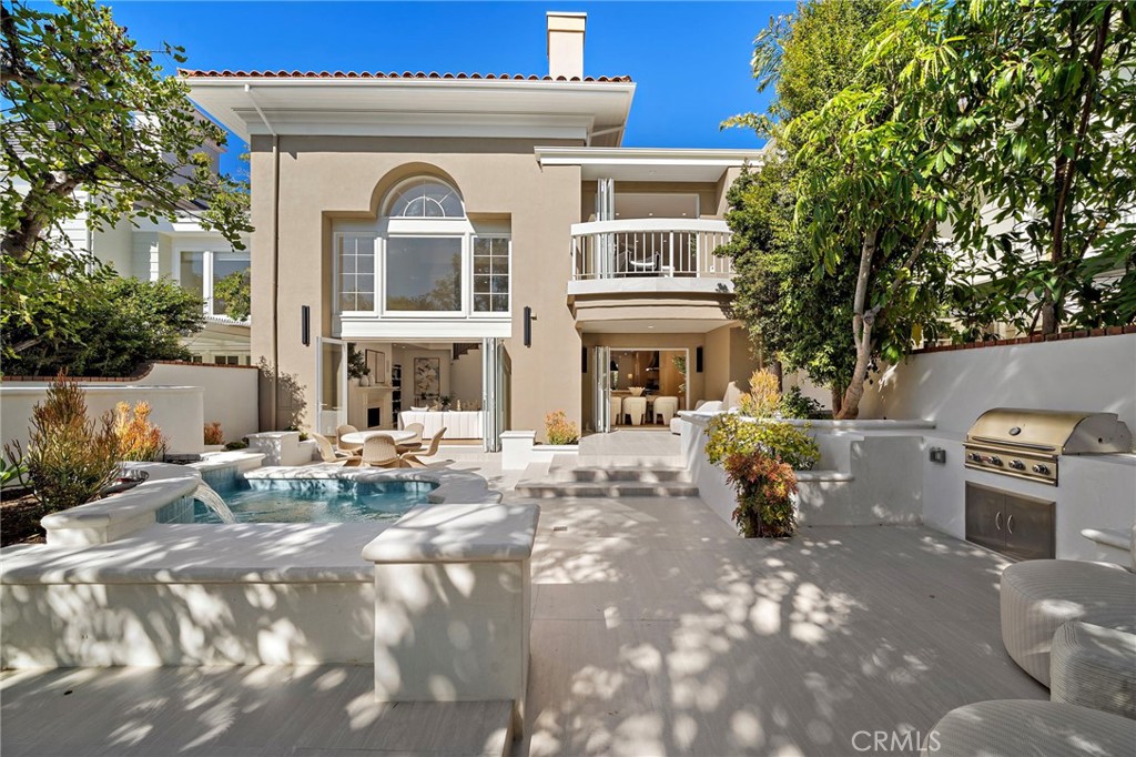 This meticulously remodeled residence in the exclusive Belcourt community of Newport Beach offers a blend of contemporary sophistication and luxurious appointments, perfect for those seeking the pinnacle of coastal living. Step inside to a world of exquisite design, where the property has been thoughtfully redesigned with the highest-grade finishes and an exceptional open-concept layout. Soaring ceilings greet you upon entry, setting a tone of spaciousness and grandeur. The gourmet kitchen, a culinary enthusiast's dream, boasts a massive eighteen-foot center island, topped with the sleek Taj Mahal quartzite natural stone counters. Custom cabinetry crafted from solid white oak and adorned with designer-selected hardware adds to the kitchen's refined aesthetic. Top-of-the-line appliances, including a professional-grade Hallman stove, ensure exceptional culinary experiences. Rich white oak flooring flows seamlessly throughout the entire home, creating a cohesive and elegant ambiance. The exceptionally spacious living area is enhanced by elegant Bonelli Italian bi-folding doors that open up to reveal the private backyard oasis. These sophisticated doors blur the lines between indoor and outdoor living, perfect for entertaining or enjoying the idyllic Southern California climate. A versatile ground floor bedroom with an En suite bathroom offers the potential for a second primary suite, providing flexibility and convenience. Ascend the grand staircase to discover the luxurious primary suite, featuring its own private patio that overlooks the lush greenbelt and offers a tranquil escape. The primary bathroom is a masterpiece of design, showcasing elevated luxury appointments, a massive shower with multiple water features, and a lovely soaking tub, creating a spa-like retreat within the comfort of your home. The exceptionally private backyard is an entertainer's delight, featuring a sparkling spa for year-round enjoyment and a well-appointed barbecue area, perfect for hosting gatherings with friends and family. Situated on a prime lot, this home offers direct access to the inviting greenbelt area, where residents can enjoy additional amenities, including a community pool and spa. This desirable Newport Beach location provides access to a multitude of high-end shopping, dining, and entertainment options, including the renowned Fashion Island. Enjoy the finest in Southern California Coastal living in this truly exceptional Belcourt residence!