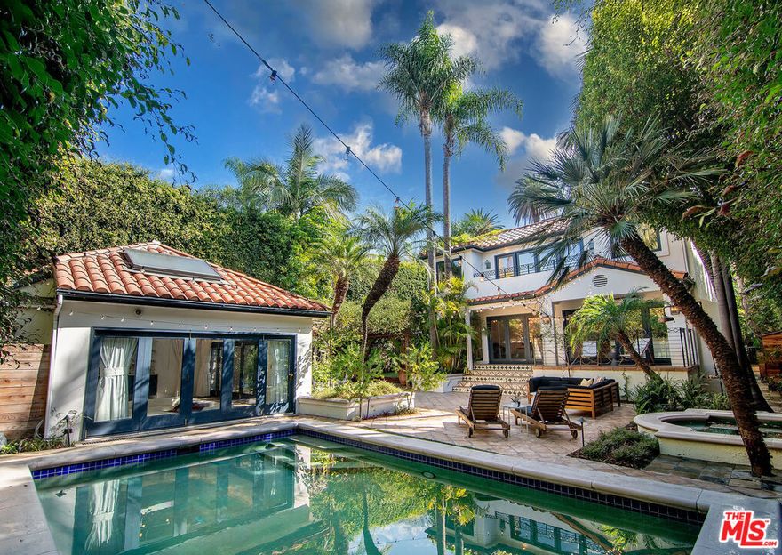 ULTRA-STYLISH SPANISH SANCTUARY WITH POOL, SPA AND CABANA IN WEST HOLLYWOOD AREA. This magnificent contemporary home, ideally located on one of the most coveted streets in the West Hollywood area, was designed with custom fixtures and finishes throughout. The entry features a built-in two-sided fish tank, with multiple glass doors on the first level creating an amazing indoor/outdoor flow. All bedrooms are en suite including an incredible primary suite offering a large walk-in closet, skylight, balcony and luxurious bath with dual sinks, large steam shower and soaking tub. The first level includes an expansive open living room and dining room, a gourmet island kitchen with Viking appliances, a step-down bar, one en suite bedroom, and a separate office with fireplace. Folding glass doors open to a private entertainer's yard surrounded by mature landscaping with a beautiful, heated pool, separate spa, trellised dining patio and a fabulous cabana/home theater with sunken couch, projection screen, bar with wine fridge, and vaulted ceiling with stained glass skylights. Additional features include an upper level second primary suite with fireplace, beautiful herringbone hardwood floors, dramatic curved staircase, water filtration system, and outdoor gym area.