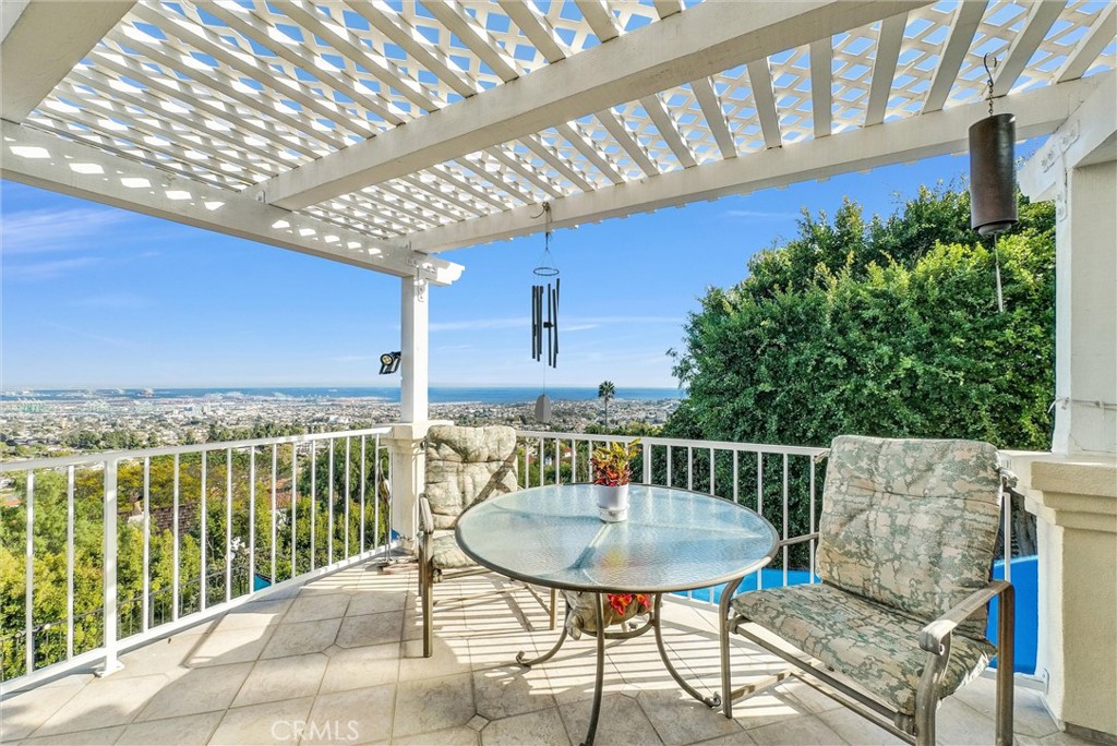 This exceptional property, located in the coveted Miraleste community, is ideal for multigenerational living. Offering 4 bedrooms and 4 bathrooms across two levels, the home is designed with flexibility in mind, featuring two fully-equipped kitchens—one on each level—creating independent living spaces. Each level also has its own private entrance, ensuring privacy while maintaining a connection between the two. Upon entering, the cozy living room greets you with panoramic ocean views and an abundance of natural light flowing through expansive sliding glass doors. The spacious master retreat offers its own ocean vista and access to a large L-shaped balcony. The master suite is complemented by an elegant en suite bathroom with dual vanities, a walk-in steam shower, a separate jetted tub, and a generous walk-in closet with custom built-ins. Down the hall, the second bedroom offers its own ocean views. Continuing through the dining area, the chef’s kitchen features ample counter space, upgraded appliances, and a breakfast nook with an ocean view. Step out from the breakfast nook to the outdoor balcony and enjoy the ocean breeze. Downstairs, the second living room offers another stunning ocean view and connects to the fully equipped second kitchen with bar-top seating—ideal for entertaining. A well-appointed guest bathroom features an oversized walk-in shower with bench seating. Two generously sized bedrooms offer ample closet space, including an additional bathroom with a walk-in shower. The spacious laundry room located on the lower level is equipped with built-in cabinetry and provides access to a versatile area beneath the home, perfect for a home gym or additional storage. The exterior of the property is equally impressive, featuring a built-in fire pit, three expansive decks, and an above-ground exercise pool. The extensive deck space offers an opportunity to enjoy the outdoors while maintaining uninterrupted ocean views—perfect for relaxation or entertaining. Enjoy the custom-built BBQ area, thoughtfully designed with a built-in sink equipped with a garbage disposal and ample countertop space—perfect for food preparation and outdoor cooking. Descending further, you'll find the lower portion of the property, an ideal space for establishing a garden or additional recreational activities. With sweeping ocean vistas from multiple vantage points, this property offers an unparalleled opportunity in one of Rancho Palos Verdes' most sought-after neighborhoods.
