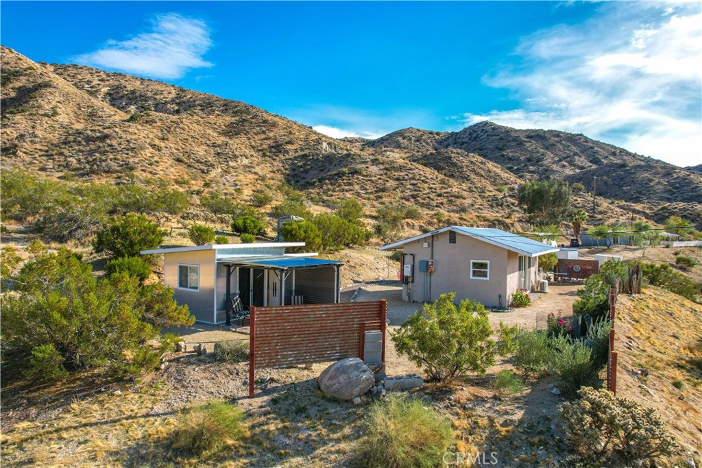 Charming Hilltop Studio Cabin Retreat on 5 acres surrounded by magical desert landscape, this cozy studio offers a perfect blend of rustic charm and modern comfort in the heart of MV.
This unique property with breathtaking panoramic views is your invitation to escape into nature. From your back door, take your own private hiking trail up the canyon leading to a viewing bench. Soak in the stunning surroundings that stretch in every direction.
Step inside to find a thoughtfully remodeled kitchen with quartz countertops, a propane stove, refrigerator – all designed to support a modern lifestyle. The updated bathroom and efficient mini-split system ensure comfort year-round. The open floor plan maximizes space and creates a warm, inviting atmosphere.
Outside, you'll discover beautiful natural landscaping, unique wood fencing and a cowboy pool for a refreshing dip-hike by day, soak by sunset.
An added bonus: a separate guest casita complete with a ¾ bath, offering privacy and convenience for visiting family or friends.
This one-of-a-kind property is a rare opportunity to embrace the peaceful, nature-filled lifestyle of Morongo Valley this hillside haven is ready to become your dream retreat.