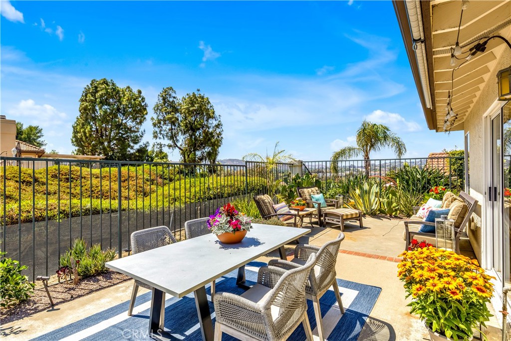 Hear the Mission Bells and enjoy the cool Coastal Breezes from this upgraded 3 bed | 2 bath + loft townhome in the sought-after community of Mesa Vista in beautiful San Juan Capistrano. Ideally situated in a private, interior location, this home lives like a single level with all the bedrooms on the main floor and a spacious, flexible layout throughout. Step through the gated front courtyard into an open living area filled with natural light and accented with a gas fireplace and tile floors. Sliding glass doors lead to a beautifully landscaped wraparound patio with golf course, city lights, and Mission views—perfect for indoor/outdoor living. Custom built outdoor kitchen and grill area includes a stainless gas barbecue, refrigerator and custom drawers and makes this back yard a perfect place to entertain. Spacious, comfortable and with room for multiple seating areas, it is the perfect spot to enjoy sunset views looking out to the historic San Juan Capistrano Mission. The interior kitchen is upgraded with granite countertops, wood cabinetry, recessed lighting, tile flooring and at counter seating and is open to the eating nook with patio access. Separate dining room offers the perfect entertaining area or it can be an ample flex space for more modern use of space. All 3 bedrooms are located on the main floor which allows for ultimate single level living. Main-floor primary suite offers a private patio and a renovated en-suite bath with step-in shower, custom vanity, tile flooring, and walk in closet. Two secondary bedrooms are large enough for queen sized beds and a large loft provides space for guests, a home office, or bonus area. Other highlights include an attached 2-car garage with direct access, garage overhead storage, washer and dryer, newer air conditioner (2023), furnace (2023), newer window shades (2023), modern light fixtures (2025), bathroom fixtures (2025), newer interior paint and carpets (2022). Nestled in the rolling hills of historic San Juan Capistrano, Mesa Vista offers 3 pools/spas, and optional RV parking. Enjoy the lifestyle this home offers being just minutes away from award-winning schools, shopping, hiking trails, world-class beaches, fine dining, equestrian facilities, golf courses, and the charming downtown area. All this and easy freeway access! WELCOME HOME!