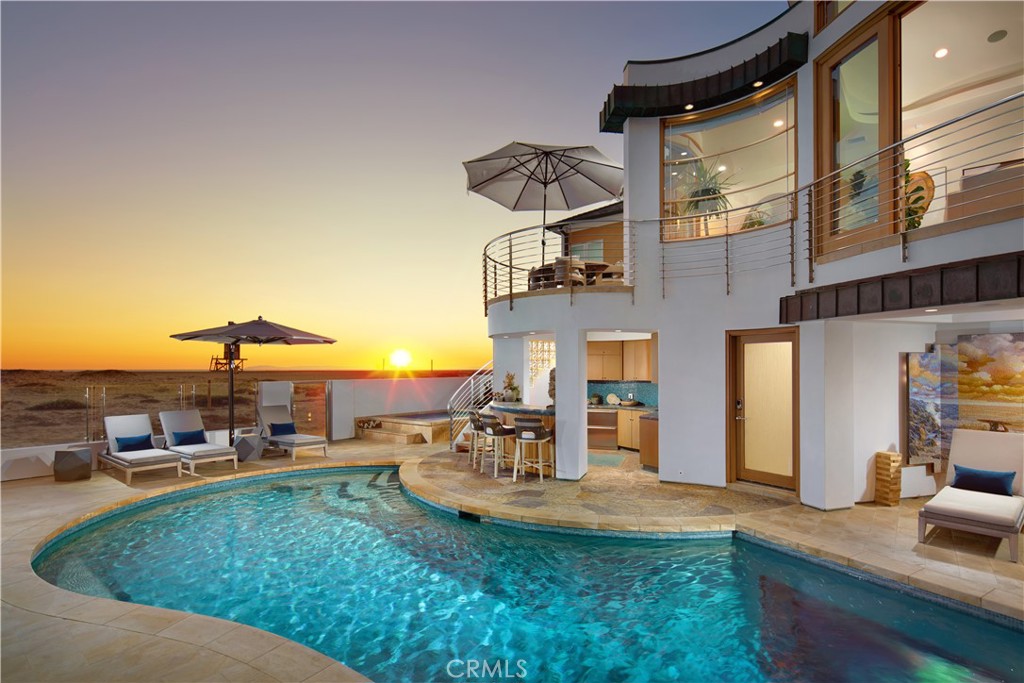 Directly on the sand in Newport Beach’s prized Peninsula Point enclave, this phenomenal architectural showplace offers panoramic views, enviable privacy, and a
virtually endless list of luxurious amenities. From the artistic mind of architect Martin Kollin, a main home and detached guest house with a total of 7 bedrooms
and 10.5 baths in approximately 7,083 square feet occupy a rare double lot with 80 feet of beach frontage and no boardwalk infringing on privacy. A magnificent
double-height foyer with a floating circular staircase and a domed skylight welcomes you into the residence, which has been featured in print and on TV.
Emphasizing the home’s upscale modern aesthetic, a remodeled kitchen showcases a large island and separate peninsula bar, stone countertops with a full tile
backsplash, a walk-in pantry, sleek white cabinetry, and stainless steel appliances, including a five-burner Wolf gas cooktop, Dacor double wall oven, Bosch
dishwasher, and built-in Sub-Zero refrigerator. The kitchen flows seamlessly to a spacious dining room and family room, where sliding glass pocket doors open to
the beachfront patio. Impressive entertaining is easy in the lower level’s bar and media lounge, which is highlighted by a massive 12-foot by 4-foot saltwater
aquarium that offers underwater views of the pool. Comprising the entire oceanfront side of the second level, the primary suite is a sanctuary unto itself, complete
with a view-enhanced sitting room with fireplace, a private view balcony, lofty barrel ceiling, and walk-in closet. The primary bath is illuminated by a large skylight
and hosts a jetted tub with a glass waterfall-style filler and a glass-enclosed shower. Guests will feel right at home in a separate residence with ocean views, full
kitchen, living room, 2 bedrooms, 3 baths, and a deck with stairs leading to the pool below. The private pool and spa terrace is primed for memorable entertaining
and features an outdoor shower and fully appointed walk-in bar.