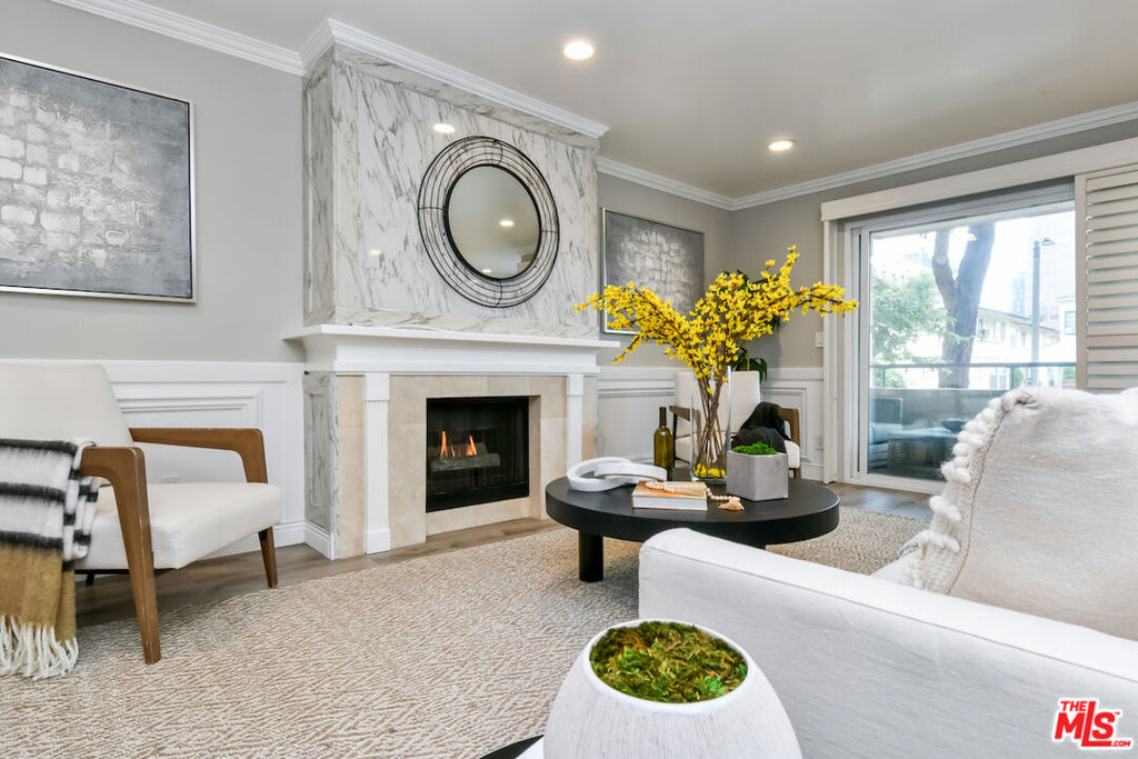 Absolutely turnkey and beautifully renovated, this single-level, front corner condo is the one you've been waiting for. With a smart, open-concept layout connecting the living room, dining area, and kitchen, it's an entertainer's dream. The inviting living room is anchored by a stylish fireplace, dry bar, and access to a private, east-facing patio; the perfect spot for morning coffee or quiet evenings. Enjoy peaceful views from every window. The cook's kitchen provides stainless steel appliances, abundant warm tone cabinetry and extensive countertops allowing your culinary adventures come to life. Opposite the kitchen, you'll find two spacious bedrooms and two full bathrooms. The primary suite features a walk-in closet and a newly updated bathroom with dual sinks and separate tub and shower. Both bedrooms offer large windows overlooking sun-dappled greenery bringing in gorgeous, filtered light throughout the day. Additional highlights include an in-unit laundry room, no shared walls, abundant storage, parking for two cars in a secure, gated garage and a controlled-access lobby. Located within the highly rated Beverly Hills School District and just moments from premier dining, shopping, La Cienega Park, Beverly Hills Tennis & Pickleball, Restaurant Row, LACMA, The Academy Museum and David Geffen Theater. A truly special home in an unbeatable location.