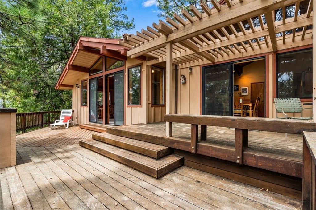 LOWEST PRICE PER SQUARE FOOT IN IDYLLWILD! Nothing compares to this home at this price! This isn't simply you finding your next home. This is YOU finding peace. Rest. A slower pace of life. Tucked away in the quaint mountain town of Idyllwild, is 26823 Crestview Drive, an inviting 2-bedroom, 2-bathroom cabin offering 1,440 square feet of comfortable living space on an 8,712 square foot lot. Built in 1977, the single-story home has much to offer. Through the main entrance, you're greeted by an open kitchen and living room area, with tall wooden plank ceilings and large windows that frame the beauty of the surrounding area. Just off the living room is a separate family room, great for gathering for a movie or board game. Both spaces have sliding glass doors that lead to the large deck off the front of the home, providing you with a lot of additional outdoor space to enjoy the tranquility of the hillside. Towards the rear of the home you'll find a primary suite with attached bathroom and an additional bedroom with a second bathroom conveniently located off the hallway. For those looking for parking and storage, this home provides PLENTY of it. A gravel driveway leads to the attached full-enclosed two car garage, perfect for long term secure storage. In addition, you have a long concrete driveway leading upto the home's main entrance and parking area. The property is conveniently close to a vibrant, local downtown area, as well as plenty of recreational trails. Whether you're seeking a mountain retreat or a year-round residence, this charming cabin combines rustic appeal with modern conveniences.