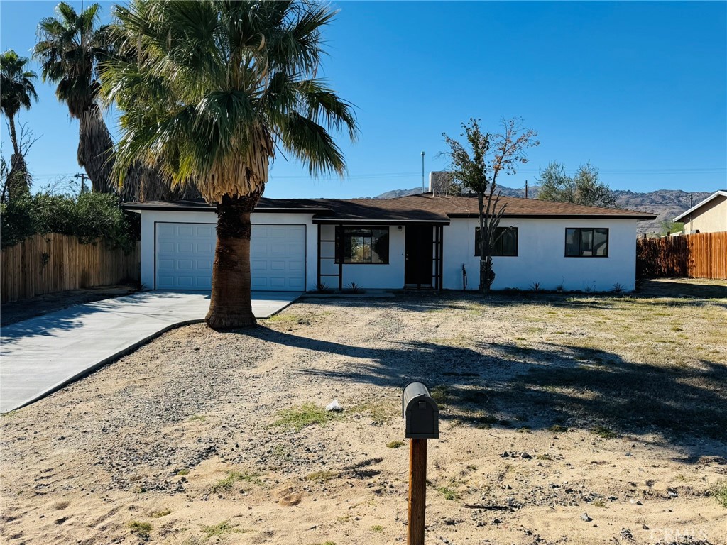 This charming single-story ranch is a great starter home, beautifully updated and move-in ready. It features a newly renovated kitchen with white cabinetry and modern fixtures, a contemporary restroom with new finishes, and new flooring throughout. The bright, open living spaces abundant natural light. Three spacious bedrooms are painted fresh and have gorgeous wood-look flooring.
Beautiful mature palm tree adding a touch of desert charm, this home includes an attached 2-car garage with storage space and a long concrete driveway that accommodates multiple vehicles. The expansive fenced backyard is perfect for entertaining, and there’s potential for RV parking.
Conveniently located just minutes from the Marine Corps Air Ground Combat Center, shopping, dining, and Joshua Tree National Park, this quiet neighborhood setting offers room to grow on this large lot. Turnkey and ready for immediate occupancy, this home is perfect for first-time buyers, military families, or investors seeking affordable desert living.