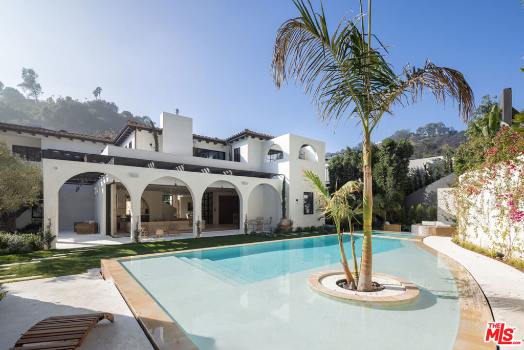 Positioned in the prestigious East Gate of the highly sought after lower Bel Air neighborhood near the iconic Hotel Bel-Air, this astonishing Spanish-Mediterranean estate seamlessly blends timeless elegance with modern sophistication. As you enter, double height glass & steel entry doors bathe the house with an abundance of natural light. Massive automated sliding door systems create the ultimate California lifestyle blurring the home's resort style exteriors with organic toned interior spaces. Adorned in custom Walnut millwork the gourmet kitchen is equipped with built-in Miele and Wolf appliances only missing a Chef's kiss. The entire home is complemented by select grade hardwood floors, handcrafted plaster walls, custom travertine stonework, and light fixtures by Apparatus and Allied Maker throughout.Featuring five luxurious bedrooms, an executive office, and a state-of-the-art theater, this home is designed for both elevated comfort and non-stop entertainment. Luxurious custom plumbing fixtures by Gessi and Graff add a spa-like touch to the primary bath, kitchen, bar & powder room. On the exterior you'll find limestone balconies, hardscaping, and a limestone-clad ADU with a roof deck that accentuate the outdoor living experience. Copper gutters, custom steel and aluminum windows and doors, and lush landscaping including 125-year-old olive trees and thousands of plants create a private, serene retreat. A three-car garage completes the offering, making this property the epitome of luxury living in one of Los Angeles' most coveted areas.