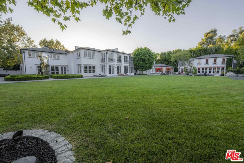 One the most spectacular and beautiful estates in Holmby Hills, situated behind gates on over 1.3 entirely level acres. A cobblestone driveway leads to a completely remodeled two story traditional estate with classic European details. Featuring a gorgeous, paneled entry foyer with sweeping staircase flooded with natural light. Large living room, formal dining, wine cellar, office, gourmet kitchen with family room & separate catering kitchen. There's a state-of-the-art theatre that can accommodate 35 people. Upstairs is the primary suite with luxurious dual baths and large closets, and a wide gallery hallway leads to all guest/family suites. There's a 2-story guest house with large gym, recording studio and guest bedrooms. The stunning grounds feature beautiful lawns, mature trees, formal gardens, a resort like swimming pool with waterfall and grotto, basketball court, spa house and an outdoor covered loggia with BBQ, bar, and pizza oven. Shown to prequalified clients only.