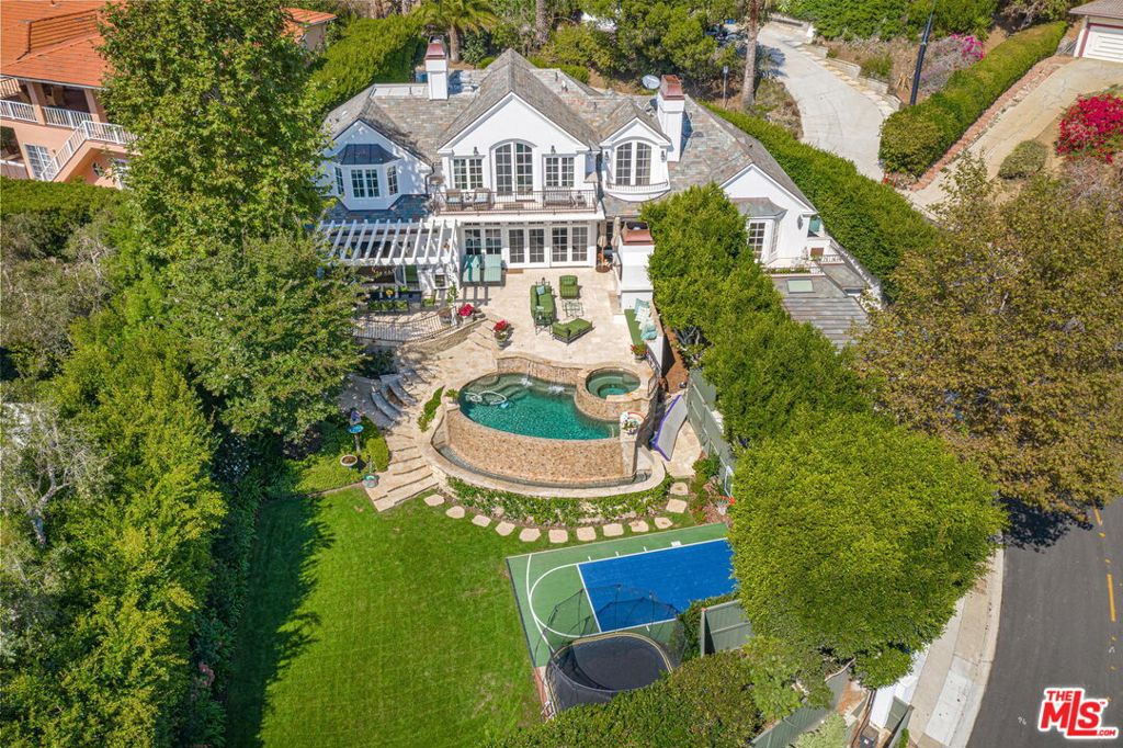 Enjoy the ocean view from this classic east coast traditional home that is warm and inviting, and filled with natural light. Pull into the new gated circular driveway, and be transformed by the Queen's Necklace views once inside. The house graciously mixes the east coast formal sized rooms, with the west coast beach lifestyle. The kitchen and family room open to views and a backyard complete with a newly enlarged entertaining patio with built-in BBQ, egg and fireplace, pool/spa, grassy lawn, sports court and trampoline area. The private master is on the top floor, along with a brand new gym, three additional bedrooms on the main floor, plus the garage has been transformed into a 2 bedroom/2 bath delightful guest or in-law suite on the lower level, along with a new temperature controlled 700 bottle wine cellar. House has been upgraded with new landscaping, new wiring, new floors, and all the bells and whistles. You will never want to leave!