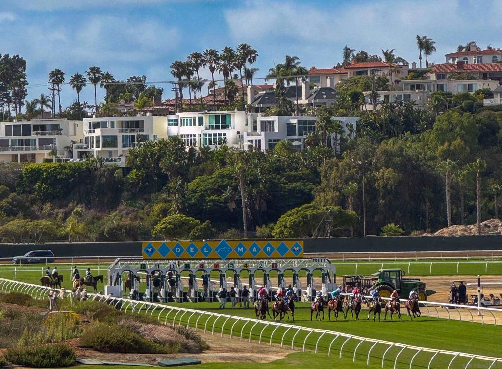 Watch the waves. See the finish line. Set above the sand and the track, this gated Del Mar residence offers nearly 4,000 square feet of living space, panoramic whitewater ocean views, and a unique vantage point of the Del Mar horse races. Fully remodeled with modern coastal vibes, the home works perfectly as a full-time residence or a lock-and-leave retreat. The main level’s great room combines expansive ceilings, oversized viewing windows, and a bar just off the living area—ideal for entertaining. Glass panels open to an ocean-facing patio with uninterrupted views of the Pacific, the Del Mar Beach Colony, and the Del Mar Race Track. Four bedrooms are arranged for privacy, including a top-floor primary retreat with sweeping vistas and a freestanding soaking tub. Additional features include a 600-bottle wine wall, Labradorite countertops that shift color with the light, a spa, and a two-car garage. On race days, the energy of the finish line carries across the track. Step outside and you’re next door to The Brigantine, minutes from Del Mar Dog Beach, and directly across from the shops and galleries of Cedros Avenue. Offered for purchase and for lease, fully furnished and turnkey.