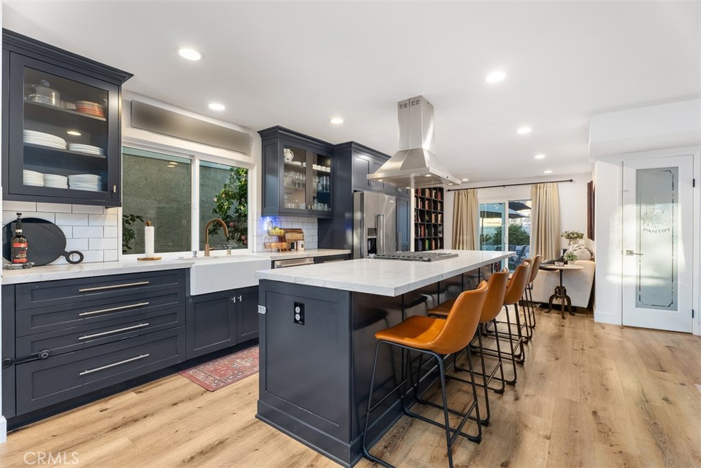 Gorgeous Lake Park home with a main floor primary bedroom and totally reconfigured kitchen! Private, gated front courtyard entrance with large open area with the garage adjacent. This home features an incredible kitchen that was done in 2020 that entailed removing walls and a dropped ceiling and now has a large island that was not part of the original floor plan and now is totally open to the dining room and main living and family rooms. The kitchen boasts custom shaker wood cabinets with soft-close drawers, a farmhouse sink, a walk in pantry, leathered quartzite countertops, and new appliances (oven replaced in 2023). Luxury vinyl flooring and new baseboards enhance the first floor, while new light fixtures add a modern touch throughout. The main floor includes a spacious primary suite with a stunning primary bathroom that has been remodeled from top to bottom with new cabinets, countertops, sinks, mirrors, shower, and has a walk in closet and access to the backyard. An additional bedroom, bathroom and laundry plus the furnace was relocated, creating extra inside storage downstairs. Upstairs there are two more bedrooms plus a brand new remodeled bathroom with walk in shower, new vanity with dual sinks, lighted mirror, and all new fixtures and finishes (2025). Off the front bedroom is a balcony overlooking the front courtyard. Additional updates include new carpet up the stairs and into the rooms upstairs (2025) new paint, a new hot water heater (2023), dual-zone AC unit (2024), and new windows in the primary bedroom and a secondary room upstairs. Two car garage that has great storage capabilities overhead. Lake Park HOA includes a community park, pool & jacuzzi. Walking distance to Laguna Niguel Regional Park, which has hiking trails, picnic areas, sports courts, fishing at the lake, and areas to rent out for parities plus a 4th of July fireworks show. Costco, Whole Foods, Sprouts, Home Depot, the newly renovated YMCA, numerous restaurants and only a few miles to world class beaches, 5-star resorts, Laguna Beach, & Dana Point Harbor currently undergoing a major renovation.