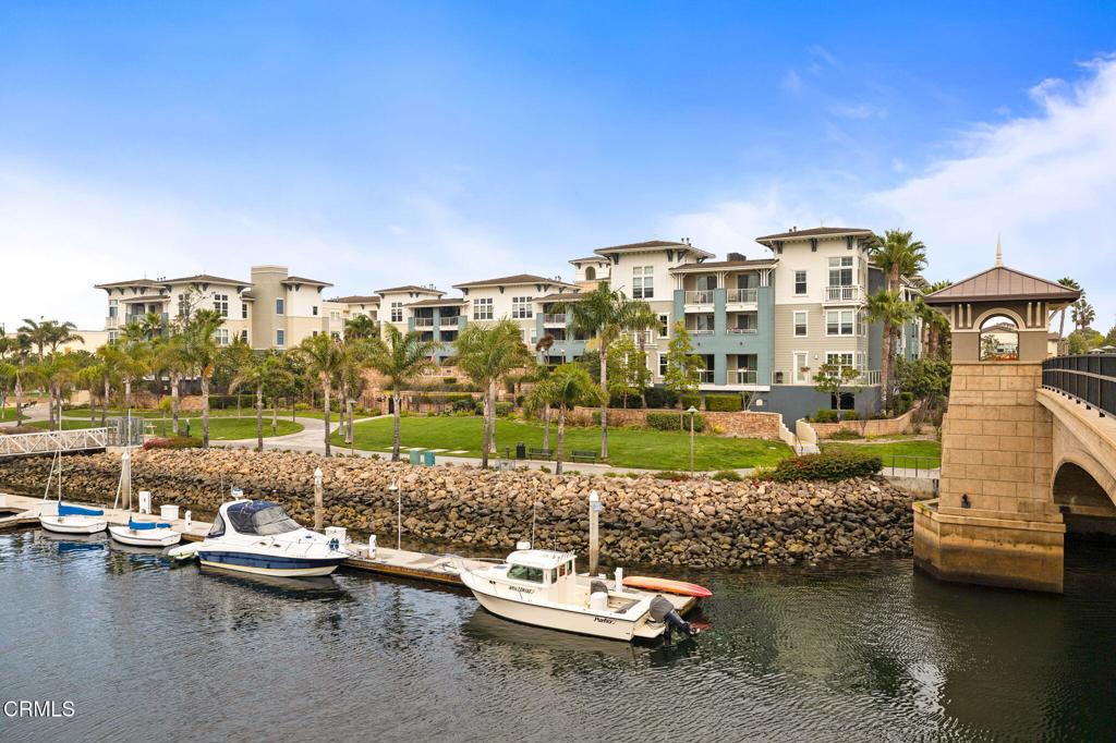 Welcome to Port Marluna, and your perfect single level condominium home or weekend resort getaway in the Seabridge waterfront community. Featuring 1700 square foot of gracious living area in a open layout with light flooding in from the living room windows and balcony, overlooking the 'Seabridge' to the Marina. The grand front entry to your building is through coded access doors with a walkway leading to your front patio and your formal entry. Once inside, the luxurious kitchen island breakfast bar greets you. The kitchen with quality wood cabinetry and granite counters, make you feel like the gourmet chef ready to cook or entertain. With all built in cooking appliances including double ovens, gas range top and microwave, (plus refrigerator.) From the kitchen, you enter the dining room, which is open to the living room, with views toward the marina. From the living room, you can walk out to your balcony and enjoy the gorgeous Southern California Sunsets and enjoy the moments. Your bright and spacious primary suite also opens to the balcony, allowing the sun to light up the room and fresh breezes to drift through. Your suite also offers a walk in closet. The primary bath includes just that, a wonderful luxury tub, separate tiled shower and two separate sink dressing areas. Inside by the guest bedroom and bath, is your laundry area and the included washer and dryer. For parking your vehicles, two assigned parking spaces are yours along with an additional storage locker that was just installed. When you are ready to relax by the water, you are within steps of a magnificent terrace equipped with lounge chairs, water feature, BBQ area and a fireplace where you can sit and enjoy the marina lifestyle. Seabridge amenities include a 365 days a year temperature-controlled heated pool, spa, clubhouse, gym, meditation/pilates room, caterers kitchen, reading room with fireplace, outdoor fire pit and bbq area with plush lounge chairs, play area for children, walking paths around Seabridge community. Make this home yours and enjoy living in the Channel Islands Marina where you can boat to the islands or boat around the harbor and enjoy the many restaurants and shops. Make it your home!