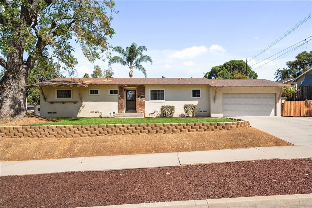 Light the pumpkin candle, grab your favorite mug and book, because you are going to FALL in love with this charming Redlands home! Nestled on a private corner lot, this delightful single-level 3 bedroom, 2 bathroom home is brimming with warmth, coziness, and modern upgrades—perfect for enjoying the crisp fall season. Step inside and be welcomed by an inviting open floor plan, where the upgraded kitchen and cozy living room immediately come into view. The living room boasts a charming fireplace, ideal for cool evenings, and large sliding doors that frame a peaceful view of the backyard. Adjacent, the remodeled kitchen shines with upgraded appliances, ample cabinet and countertop space, and a farmhouse sink overlooking your private yard and fruit trees—an inspiring backdrop while cooking or entertaining. Down the hall, you’ll find the executive suite with its own attached bathroom, offering both privacy and convenience. Two additional bedrooms and a second full bathroom provide plenty of space for family, guests, or even a home office. Upgraded flooring runs throughout the home, giving it a seamless, move-in ready appeal. Outside, the backyard is an autumn dream—featuring a spacious covered patio, plentiful fruit trees, and endless potential to create your perfect outdoor retreat. The large corner lot offers added privacy, mature landscaping, and scenic views of the peaceful Redlands neighborhood. The 2 car attached garage and large drivway offers plenty of parking PLUS additional RV/boat parking for outdoor enthusiasts! Located near the highly sought-after Cope Middle School and Smiley Elementary, plus just a short drive to vibrant Downtown Redlands with its shops, restaurants, and seasonal events—you’ll be perfectly positioned to enjoy the best the community has to offer. Don’t miss this opportunity to FALL in love with your new home—schedule your private showing today!
