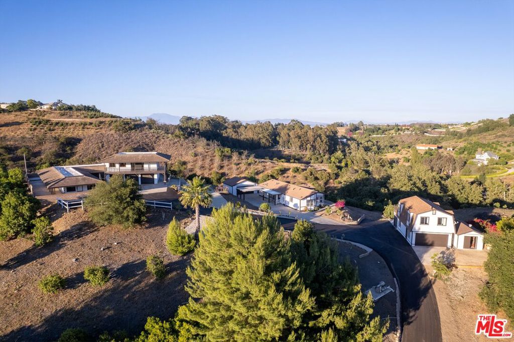 3 homes in 10 acres. A must see. Incredible opportunity to discover unparalleled opportunity in the prestigious Deluz community with this exceptional property, perfectly blending ranch living with significant income-generating from the extra dwellings. Close to old town , shops and restaurants and freeways. This thoughtfully designed features a built main house and two fully renovated, ready-to-rent homes. The main house, spanning almost 3,000 square feet, offers a versatile layout with 3 bedrooms downstairs and a private primary suite upstairs. The primary suite boasts a spacious walk-in closet and a private balcony, providing spectacular, breathtaking views of the rolling hills.Adding to the property's immense value are two additional residences. The 1,571-square-foot modular home, set on a permanent foundation, has been renovated and features 2 bedrooms (with an optional 3rd) and 2 bathrooms, complemented by a detached 2-car garage. Additionally, a charming 640-square-foot studio apartment is located within the shop/barn, presenting a highly desirable rental option.This property is ideally situated in prime De Luz area, close to town, offering both convenience and serene privacy. It includes one main power meter with two sub-meters (one for the modular home and one for the barn), ensuring efficient utility management for all residences. Enjoy the bounty of a variety of family fruit trees, mature oak trees, and a seasonal stream, all contributing to the property's charm and natural beauty. Extensively remodeled including New Roof, New Air and Heat and Water Heater.