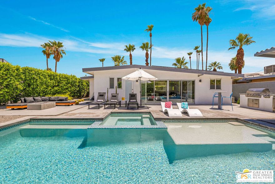 Discover this beautifully updated 1954 Meiselman-built mid-century home, perfectly situated in the heart of Movie Colony East in Palm Springs. This stylish retreat features two spacious bedrooms, two full bathrooms, and a versatile den that can easily serve as a third bedroom, home office, art studio, or gym. Recently renovated, the home has a sleek open-concept kitchen, modern bathrooms, and generously sized bedrooms. The kitchen is a chef's dream, offering panoramic views through a wall of glass that overlooks the sparkling pool and the serene mountain backdrop. Step outside and enjoy the ultimate desert lifestyle with a refreshing swim in the recently added pool, a soak in the spa, or a barbecue followed by alfresco dining beneath the built-in shade structure. As the sun sets, gather around the cozy fire pit for relaxing evenings and great conversation. The fully gated property includes a one-car garage, ample off-street parking, and a fully owned solar system with a Tesla battery helping you save on energy costs year-round. Last but not least, this home is offered turnkey furnished. Interested in rental income? Check with the City of Palm Springs about obtaining a Junior Rental Permit. Contact the agent today for a private showing of this iconic Palm Springs home!