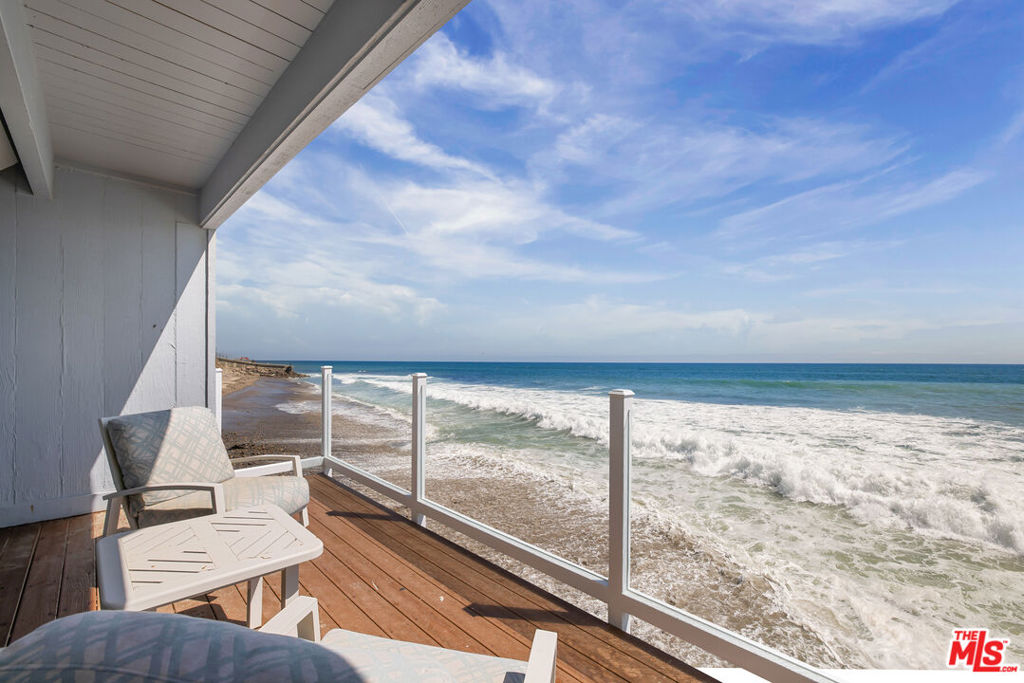 Who wouldn't want to live on the beach? Be the fortunate one to own this fabulous home, perfectly sited offering not only stunning ocean views in front but also unobstructed whitewater coastline views to the side from nearly every room in the house, and from every bedroom. Perched on a small promontory that extends beyond the neighboring houses, this turnkey home is a true dream come true. Imagine waking up to the sound of waves and stepping out through a sliding glass door that leads directly onto the beach via a private pathway. This is the closest thing to having your own private beach in California. Inside, the house is equipped with top-of-the-line Viking stainless steel appliances, ensuring your culinary adventures are nothing short of exceptional. The beachfront deck is perfect for enjoying sunsets, while the remodeled bathrooms and built-out closets add a touch of modern elegance. There are exquisite built-ins in the living room and the primary bedroom, adding both style and functionality. The primary bedroom also features a retractable TV within the cabinetry for your viewing pleasure. With stone floors downstairs and wood floors upstairs, the house exudes a seamless blend of sophistication and comfort. Your private sandy sitting area beside the house offers a serene spot for relaxation, and the wine cellar is ideal for the connoisseur. The main house features 2 bedrooms and 2 1/2 baths, providing ample space for family and friends. The detached guest house, with 1 bedroom and 1 bath, offers an astounding ocean view that will captivate your guests. The open-air courtyard is your private outdoor oasis, perfect for barbecues or cozying up by a fire pit. Parking is a breeze with a 2-car garage and room for 2 additional cars. Nestled behind gates and close to a famous surf spot, this property is truly one of a kind. Just move right in to experience the best of Malibu living.
