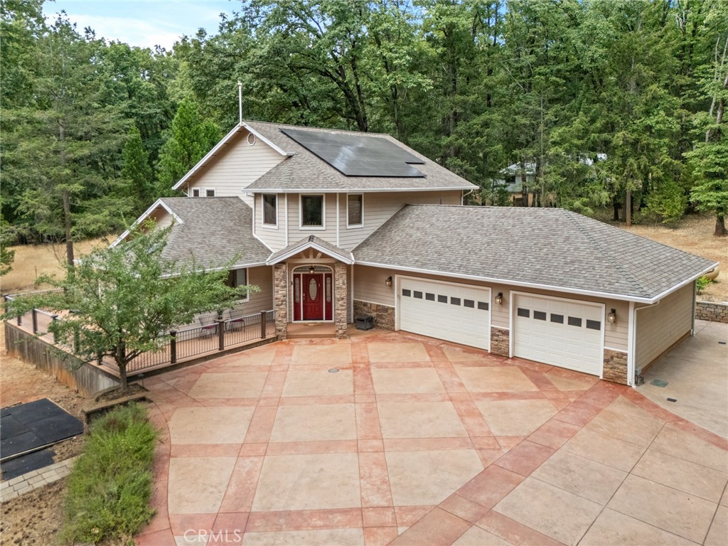 Welcome home to your beautiful mountain retreat on 5 acres! This serene property is set back from the road with a private gate, huge stamped concrete driveway and grand stone columns welcoming you to this beautiful custom home. Inside you'll find a soaring entryway with a beautiful chandelier, spiral staircase and a tile inlay compass rose making you feel that you have finally arrived home. This property was designed to be a sanctuary inside and out, with so much space and light throughout. The front living area off the entryway offers numerous windows with endless views of trees. The cozy family room off the kitchen has a wood-burning stove, built-ins, wine fridge, wet bar area and slider access to a back patio area. You'll love preparing meals in the updated kitchen with gorgeous granite countertops, custom cabinetry, stainless steel appliances and lovely tile backsplash. The adorable breakfast nook off the kitchen is the perfect place for coffee, homework or cozy meals. There's even a formal dining room for special occasions, holidays and celebratory meals and it also includes a sweet pass through to the kitchen. This layout has the best of all worlds with intentionally designed rooms to the open concept kitchen, family room and breakfast nook. Downstairs there are also two large bedrooms, two bathrooms, a huge walk-in pantry and ample storage and closet space. Wait until you walk up the beautiful wood staircase to the stunning primary bedroom retreat! There's a jaw-dropping amount of space upstairs with the massive bedroom and walk-in closet. The primary bathroom is like a spa setting with glass block shower and jetted tub with views of trees and even a two-sided fireplace where you can finally let your shoulders drop and unwind from the stress of the day. The bathroom also includes a large vanity area, separate water closet including a bidet and so much space. Truly this property was designed to be a retreat with everything you could need to relax and even includes a spa situated on the large trex deck where you can start or end your day in peace. Additional features include a 3 car garage, owned solar and the perfect horse lover setup with a horse shelter and nearby trails to enjoy with your equine friends. Peace, quiet and everything you could ask for in a beautfiully designed modern home--don't miss this one!