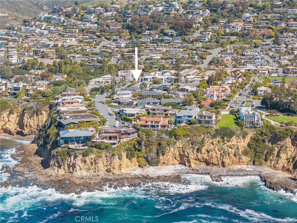 Tucked within Laguna Beach’s coveted Crown Point neighborhood, 169 McKnight is a rare single-level coastal home that invites you into a world of timeless beauty and effortless living. Located on the ocean side of Pacific Coast Highway and just blocks from Crescent Bay Beach, one of Laguna’s most beautiful coves, this home is surrounded by mature trees, lush landscaping, and a garden setting that feels peaceful, private, and distinctly coastal.
Lovingly maintained and thoughtfully designed, this shingled home blends indoor comfort with outdoor serenity. The living spaces center around a sun-filled courtyard that welcomes coastal breezes and natural light, creating an intimate setting for dining, entertaining, or simply enjoying the flow of everyday life. Inside, high tongue and groove wood ceilings, rich hardwood floors, and a classic wood-burning fireplace add warmth and character throughout. Two guest bedrooms sit just off the main living space, one with built-in workstations ideal for creative pursuits or remote work. They share a beautifully updated bath with timeless finishes. The spacious primary suite is a private haven with its own access to both the courtyard and a tranquil backyard garden. The en-suite bath features dual vanities, a soaking tub, and an oversized walk-in shower that complements the home’s elevated coastal style.With its thoughtful layout, enduring style, and enviable proximity to everything that defines the Laguna Beach experience, 169 McKnight is just minutes from Crescent Bay Beach, downtown, acclaimed restaurants, art galleries, and boutique shops. This coastal gem in one of Laguna’s most sought-after neighborhoods offers a timeless setting to enjoy the very best of Laguna Beach living.