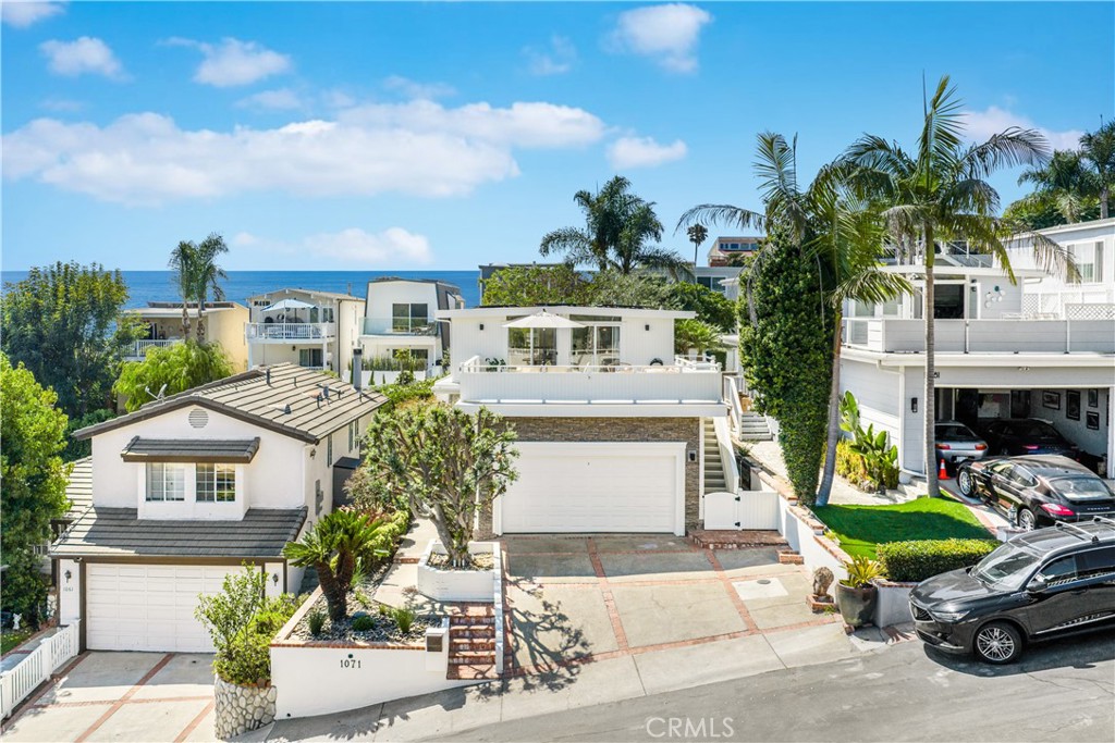 This charming, highly upgraded home offers stunning ocean views and is located moments from downtown Laguna Beach. The open floor plan on the upper level includes an expansive living section, a dedicated dining area, and a recently remodeled kitchen - all connected to the attached deck of impressive proportions via two sets of sliding doors. A perfect backdrop for enjoying the coastal lifestyle, with the panoramic canyon, city, and Pacific vistas visible through the oversized windows and from the adjacent balcony which doubles as an outdoor living area. The kitchen is an ideal gathering place and features a sleek waterfall edge island, new cabinetry, and elegant finishes. A bathroom completes this level. On the ground floor, three bedrooms share a bath and the spacious primary retreat connects to the home’s private, fenced in yard. New hardwood flooring throughout the main areas adds to the property’s refined aesthetic and a two car garage provides further storage. The coveted Arch Beach Heights neighborhood is known for its proximity to Moulton Meadows Park and offers easy access to Downtown, providing a perfect blend of comfort and convenience.