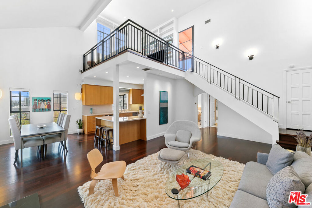 Experience refined living in this rare two-story penthouse at 412 Arnaz Dr. Positioned on the top floor, south-facing corner, this light-filled residence offers dramatic soaring ceilings, expansive feeling open-concept living, and upscale designer finishes all just moments from Beverly Hills, The Beverly Center, West Hollywood, and world famous Los Angeles restaurants. Step inside to discover a spacious and sophisticated floor plan, ideal for entertaining. The main level features a modern chef's kitchen with limestone countertops, Sub-Zero refrigerator, Viking range, Miele dishwasher, and abundant cabinetry, all flowing seamlessly into the open living and dining areas. Oversized windows capture brilliant southern light and showcase the home's stunning volume and scale. The first floor also includes two generously sized bedrooms and two beautifully updated bathrooms, including a luxurious primary suite with a huge cedar-lined walk-in closet and spa-like bath. The second bathroom features a glass-enclosed oversized tiled shower and a large vanity with sleek finishes. In-unit laundry, custom storage, and warm wood floors complete the level. Upstairs, a stylish loft with built-in shelving overlooks the living room and offers the perfect space for a home office, library, or media lounge. Step outside to your private covered rooftop deck perfect for outdoor dining, entertaining, or simply relaxing with expansive city views. A rare bonus storage room off the deck adds even more convenience, offering space few condominiums provide.One of the most unique features of this penthouse is the private two-car garage with direct access to the building lobby an extremely rare amenity in condo living. The garage is equipped with EV charging outlet, offers additional room for storage, and is accessed from the side street.Located in a secure, well-maintained building in one of Los Angeles' most sought-after neighborhoods, this stunning penthouse is Beverly Hills adjacent, close to shopping, fine dining, galleries, and major studios..
