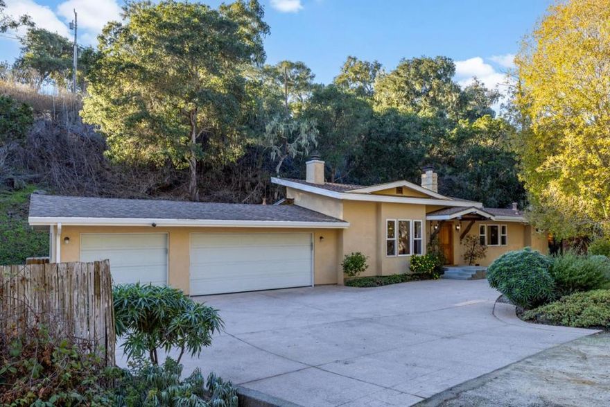 Find tranquility in a Monterey neighborhood that places you minutes from exceptional restaurants and legendary golf. Just down the street from Del Monte Golf Course (the oldest operational course west of the Mississippi), this single-level home sits on half an acre of tree-studded land. Set back from the road and fronted by an expansive driveway, it offers a palpable sense of privacy and calm. Step into a chic, warm living room, where elevated ceilings draw your eye upward and into the heart of the home. Wide-plank Douglas fir floors lead past a fireplace into a second, more informal living space. High-set picture windows emphasize the elegant pitch of the ceiling and frame lush glimpses of an ivy-covered hillside. Use this room as a study, a dining room, or that elusive thing you've always dreamed of having in a home. A pass-through window connects a breakfast bar to a beautiful kitchen with custom cabinetry, granite countertops, stainless steel appliances, and a gas range. With sliding glass doors in two of three bedrooms and wide windows seemingly all around you no matter where you stand, this home delivers effortless indoor-outdoor living. Come discover all the wonderful built-ins and luxurious finishes throughout this home, and start living your life the way you really want.