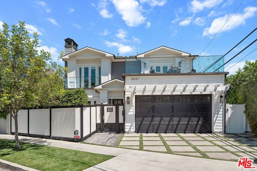 Welcome home to classic East Coast elegance, seamlessly blended with modern California living. With a newly adjusted price, this property combines timeless appeal with outstanding value. Privately gated and masterfully crafted, this five-bedroom, five-bathroom estate is nestled south of Ventura Boulevard on one of Encino's most desirable streets. Spanning over 3,600 square feet of refined interiors and resort-caliber amenities, this home offers elevated living at every turn. A gated front courtyard welcomes you into a serene garden sanctuary featuring lush landscaping, a vegetable and flower garden, and a peaceful sitting area. Step inside the grand foyer where double-height ceilings soar over 20 feet, accented by intricate moldings and a dramatic statement staircase and hand-blown glass chandelier. Wide-plank European oak floors in rich natural tones contrast beautifully against bespoke black coffered ceilings, setting the stage for timeless sophistication. The formal living room is anchored by a stately fireplace and surrounded by oversized windows, offering warmth and light in equal measure. The elegant dining room features mirrored paneling and designer lighting, creating the ideal backdrop for intimate dinners or festive gatherings. A butler's pantry leads to the showpiece of the home, the family kitchen. Open to the family room and anchored by a massive center island with waterfall quartz countertops, this chef's kitchen is outfitted with premium JennAir appliances, custom cabinetry, and a built-in wine display wall. The space flows seamlessly into the sun-drenched breakfast area and inviting family room with modern fireplace and an indoor-outdoor experience through expansive glass accordion doors. Upstairs, the primary suite is a private retreat with a fireplace, vaulted ceilings, and French doors opening to a sprawling balcony with treetop and canyon views. The spa-inspired bathroom offers a freestanding soaking tub, dual vanities, oversized rain shower, and boutique-style walk-in closet. Additional upstairs bedrooms are all ensuite and beautifully appointed with access to balconies. The backyard is a true oasiscomplete with a sparkling pool and spa with a waterfall feature, custom wood decking, built-in barbecue, covered patio, and multiple areas for lounging and entertaining. Additional features include a spacious main-level guest suite, upstairs laundry room, integrated surround sound, smart home technology, automatic blackout shades, wired security system, and a two-car garage with direct entry. This home offers easy access to Encino's finest amenities including top-rated schools, Equinox, Trader Joe's, Encino Commons, Balboa Park, Los Encinos State Historic Park, El Caballero Country Club and the 101 freeway. Whether you are dining out, shopping, or seeking nature and wellness, everything is just minutes away.
