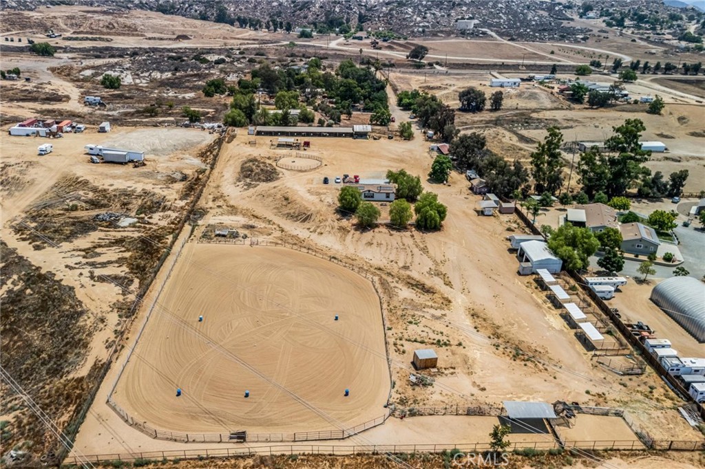 Functioning 5 acre Horse Ranch/Boarding Facility, complete with 200x150 arena, round pen, mare motel, barn, turnouts, oversized stalls 24x24, 20 stall capacity (with room for more), tack rooms, wash racks, newer automatic waterers installed in stalls, 20 Ft. Conex box, two Tuff Sheds, and direct access to several miles of trail riding right outside the gate. The arena is ready to ride, rope, run barrels, and has amazing footing in case you want to do lessons or just ride from dusk to dawn. This property also offers its deep water well WITH NO water bill (new motor for well recently installed with 6-year warranty), propane, RV hookups with separate sewer connection, and 50 amp plug-ins for your guests too. Did I mention there is a fire hose hook up, which cut the current fire insurance bill in half... The property is fenced and has automatic gates with a combination for access and safety. The home itself offers 3 bedrooms, 2 bathrooms, a separate laundry room, a pantry, a large kitchen open to the family room with an open floor concept for entertaining, a fireplace, and more. You can also access the inside of the home from the laundry room to keep the mud out. The home also offers a full-length patio cover for BBQs, gatherings, and more. This property is conveniently located just off the 215 Interstate and Highway 74 for easy access. Whether you are looking for a property to run a business of boarding and perhaps a lesson program, or just run your horses and livestock, this property may be just what you've been waiting for.