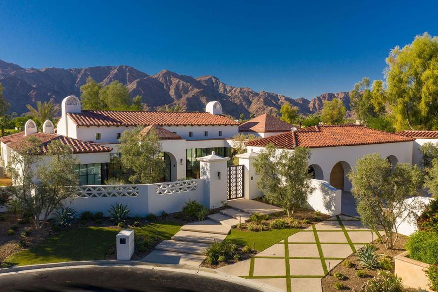 Wowza! This new construction Modern Hacienda custom estate sits at the end of a quiet cul de sac with jaw dropping, panoramic mountain views on an expansive pie shaped lot at Tradition Golf Club.  Cutting edge architecture from renowned architect Gordon Stein featuring dramatic beam ceilings, intimate atriums, endless walls of glass and indoor-outdoor living at its finest.  Motorized black pocketing doors open the Great Room up to the incredible outdoor beam ceiling patio with festive Bar, BBQ, and cozy fire pit. Wide plank oak wood flooring throughout and gorgeous transitional fixtures and finishes are playfully put together like no other house on the market. The sleek Kitchen is a masterpiece with gourmet appliances, waterfall porcelain slab island and flat panel custom cabinetry.  The Great Room is simply stunning with a porcelain slab fireplace and timeless feel. On the way to the Master Suite, you will find a cool Office Nook and be dazzled by the divine tile wall in the Powder. The Master Suite has a peaceful, casual interior design with a Master Bath that should be in magazines.  Family will enjoy the two Guest Suites in the main house, as well as the Casita with Living room, Kitchenette, and Bedroom w/ ensuite.  Smart home with Crestron enabled audio visual systems.  Furnished per inventory and is ready for the season!