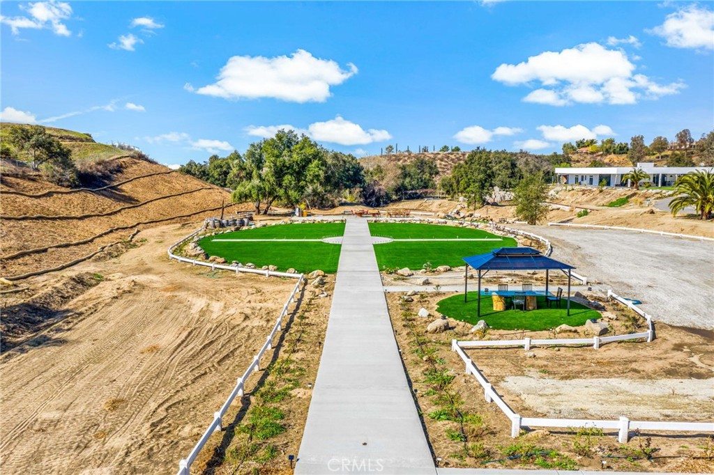 TEMECULA WINE COUNTRY Incredible 15+ Acre Estate with Endless Business opportunity Potential on the De Portola Wine Trail! This remarkable 15.14-acre estate, located along the highly sought-after De Portola Wine Trail, offers an unparalleled opportunity to transform your vision into reality. Whether you dream of establishing a winery or wellness retreat, this property provides the ultimate blank canvas for your next big venture. In addition to its prime location, the estate boasts a perfect grading pad and plenty of hillside land, giving you ample space for further development, agriculture, or unique outdoor experiences. Just beyond the gated entry, the estate’s sprawling 8,000+ square foot main home greets you with a true grand room designed for both opulence and functionality. The chef-inspired kitchen is a showstopper, featuring elegant chandeliers, dark cabinetry, stainless steel appliances, and a generous island that comfortably seats up to 10 guests, all while offering breathtaking views of the property. The adjoining banquet-sized dining area is enhanced with stunning overhead lighting, built-in storage, and a luxurious living space that combines both vastness and panoramic views of the estate. With 4 spacious bedrooms, each featuring walk-in closets and ensuite bathrooms, and an additional guest half bath, the home is designed to accommodate your every need. Enjoy the convenience of a huge pantry, laundry room, workshop, and even a wine room perfect for connoisseurs. The property’s potential doesn’t stop there. The home includes 4 unfinished rooms, adding another 2,160 square feet, along with an expansive, unfinished banquet hall/tasting room offering an additional 2,117 square feet of space. This gives you a staggering amount of square feet of indoor area to mold to your specifications. Step outside into the jaw-dropping 3,781 square foot outdoor retreat, where a full bar that seats 20, an outdoor grilling area, a cozy fireplace, and ample entertaining space await—ideal for hosting guests while taking in the sweeping views. Located in a prime area and this property is primed to host a multitude of business possibilities, from a boutique winery or luxurious wellness center to an exclusive event space. The potential is truly limitless with over 15 acres of space for development. Your imagination is the only limit on this one-of-a-kind estate! Don’t miss out on this rare chance to own a piece of paradise on the De Portola Wine Trail!