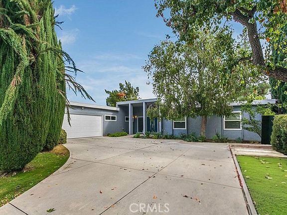 Luxury, light, and location - this fully remodeled Woodland Hills single-story offers a sparkling pool, modern finishes, and a prime setting near top neighborhood attractions. Completely remodeled throughout, this 4 bed, 3 bath home sits on a 16,817 sq ft lot and offers approx. 2,394 sq ft of light-filled living space with brand-new windows, sliding doors, and recessed lighting. The spacious living room features a custom-tiled fireplace, while the separate dining area offers backyard views and seamless flow for entertaining. The stunning custom kitchen boasts stainless steel KitchenAid appliances, quartz countertops, new cabinetry, and bar seating — perfect for gatherings. The primary suite includes a remodeled bath with designer finishes and generous closet space. Additional highlights include dual central air, a large laundry area, and a 2-car attached garage. Outside, enjoy a beautifully landscaped backyard with new hardscape and a fully re-plastered pool, creating your own private retreat. Ideally located near The Village, local shops, restaurants, and popular community spots.