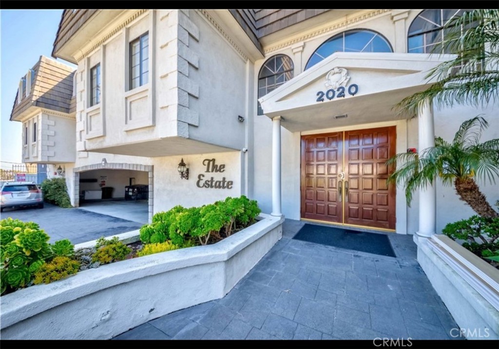 Located in the quiet, Mediterranean-inspired The Estate complex, this top-floor, corner unit offers privacy, natural light, and sweeping views of the city, harbor, and Palos Verdes Hills. This spacious, single-level condo features a formal living room with a cozy fireplace and custom plantation shutters throughout. French doors open to a fully enclosed glass patio perfect for enjoying the views. The formal dining room flows into a large kitchen with a separate pantry and laundry room. The expansive primary suite includes a walk-in closet and en-suite bath with dual sinks. A generously sized second bedroom and a full hallway bath provide comfort and flexibility. Enjoy direct access to elevator and 2-car indoor parking, private storage room, resort-style amenities: Olympic-sized pool framed by Greco-Roman statuary, large in-ground spa, expansive sundeck, elegant clubhouse with saunas, showers, full kitchen, and outdoor BBQ area. Prime location near shopping, parks, and the sea all within walking distance