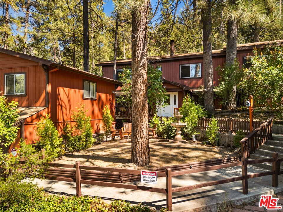 Private Mountain Retreat -Two Homes in One, Steps from Idyllwild Arts Academy. Situated just down the street from the prestigious Idyllwild Arts Academy, this secluded property offers the rare opportunity to own not one, but two completely separate residences. The main home exudes rustic mountain charm with its warm redwood exterior, beamed ceilings, and expansive decks, while a fully independent 500 sq ft, 1-bedroom cabin sits privately above the garage with its own exclusive entrance; ideal for guests, extended family, or rental income. Inside the main home, natural light fills the gorgeous sunroom, which opens to a versatile bonus space perfect for an indoor hot tub or lounge area to enjoy snowy winter nights in comfort. The spacious living room features vaulted beamed ceilings, a fireplace, and picture windows that frame the forested setting. Expansive decks with a built-in bar and BBQ area create a seamless flow between indoor and outdoor living. Terraced landscaping, mature trees, and a tranquil fountain enhance the sense of privacy, while the detached two-car garage and additional driveway parking provide convenience. Both residences offering complete independence. Homeowner Favorites: Relaxing or reading on the back decks in complete privacy, surrounded by nature. Sitting on the front porch with a fountain view, watching birds come and go while listening to their songs. Enjoying the absolute peace and silence of the evenings, with sunlight streaming into the living room and office space in summertime. Watching snowstorms in winter through the large living room windows. Walking through the fragrant lilac bushes in springtime on the way to the front door and admiring the changing colors of fruit trees and lilacs in fall as the sun sets. This property is ideal as a year-round home, vacation retreat, or exclusive dual-income investment.