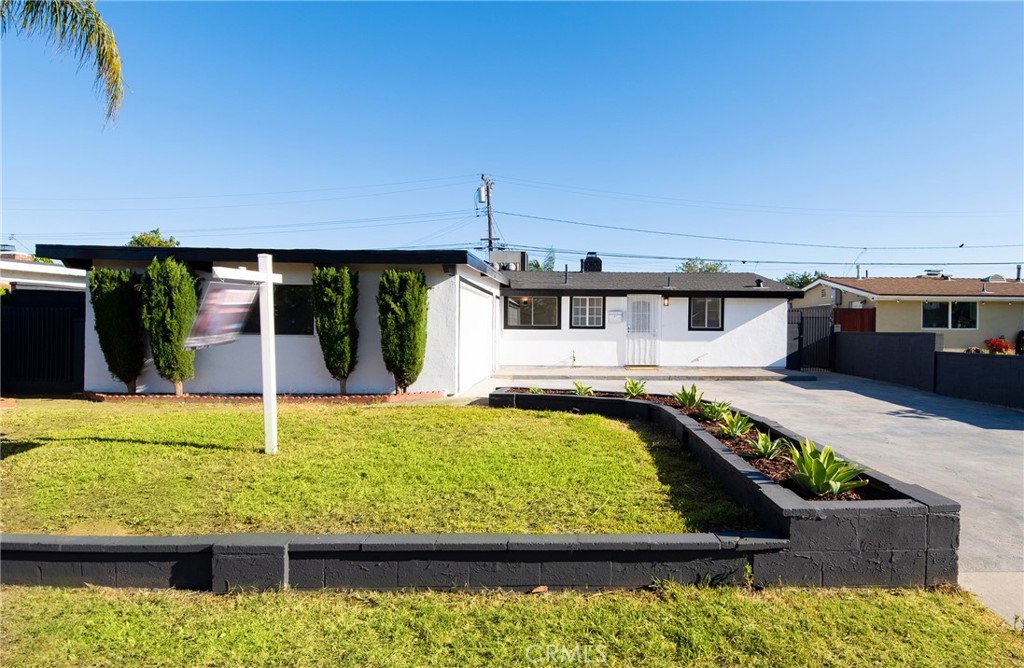 Step into modern comfort and timeless charm in this beautifully upgraded 4-bedroom, 2-bathroom home tucked away in a desirable La Mirada neighborhood. Thoughtfully renovated inside and out, this home features fresh interior and exterior paint, new wide-plank vinyl flooring throughout, recessed lighting, and stunning vaulted ceilings with exposed black beams that add architectural character and volume to the space. The total habitable space is roughly 1,519 Sq. Ft., of which 375 Sq. Ft. of that is a permitted and finished enclosed patio, and the original home of 1,144 Sq. Ft.
The brand-new kitchen is a true showstopper, featuring new sleek quartz countertops, soft-close white cabinetry, and a stylish backsplash that flows seamlessly into the open living and dining areas. A bold, black-painted double-sided fireplace anchors the living space, creating a warm and contemporary focal point.
The high, wood-paneled ceilings and exposed beams continue in the bedrooms, enhancing the sense of airiness and charm. One of the bedrooms features double doors and a textured brick accent wall, ideal for a home office or creative studio. The other 3 bedrooms offer bright natural light, spacious layouts, and mirrored closet doors.
Both bathrooms showcase stylish upgrades. The hallway bath boasts warm-toned, large-format ceramic tile, a pedestal sink, and a tub/shower combo with an elegant frosted glass enclosure. The second bathroom offers a more modern aesthetic with slate-gray tiled flooring, a wood-tone vanity topped with quartz, matte black fixtures, and a sleek glass shower enclosure.
Step outside into your private backyard, complete with a functional storage shed and plenty of space for outdoor entertaining, gardening, or relaxation. This move-in-ready home is conveniently located near local parks, schools, and shopping centers.
