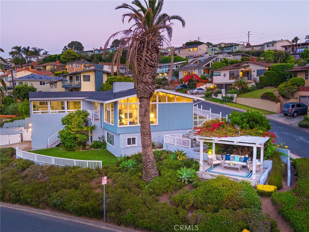 Perched high on a corner lot in the prestigious coastal enclave of Hollywood Riviera, this unique remodeled residence offers breathtaking 180-degree views (no power lines)—from the sparkling Pacific Ocean and harbor to the city skyline, downtown and snow-capped mountains beyond. Sunsets are truly spectacular from this elevated vantage point and twinkling city lights create an unequalled ambiance.
Inside, discover open, airy living spaces with vaulted, wood-beamed ceilings and walls of windows that frame the panoramic scenery. The spacious Living Room features a cozy fireplace, built-in wall library and seated views that extend through to the Dining Room with direct access to both front and back yard areas.
The bright, remodeled Kitchen overlooks the pool/patio/BBQ area and includes stainless appliances and a cheerful corner Breakfast Nook. All three bedrooms are en-suite with private baths. The Primary Suite, tucked in the rear corner for privacy, boasts two walls of windows, wood-beamed ceilings, walk-in closet, wood flooring and a luxurious, private bath with step-in shower, soaking tub and dual vanities.
Downstairs, a large Family Room with kitchenette opens to the pool/spa patio—ideal for entertaining young and old! This level also includes Bedroom 3 (with its own views and private bath), a separate guest half-bath (right off the pool/patio) and a fully-appointed Laundry Room with sink, counter and cabinetry storage, plus an extra storage area.
Large in-ground sparkling pool and relaxing spa with big view patio, BBQ and outdoor shower are the perfect setting for entertaining!
Enjoy five distinct outdoor areas: turf-covered front and back yards, pool/patio with BBQ and outdoor shower, gazebo lounge and multiple spaces for al-fresco dining and relaxation – plus the most delicious orange tree ever!
Attached two-car garage with direct access and generous driveway for multiple vehicles.
Located near world-class beaches, shops and dining of vibrant Riviera Village, award-winning Torrance schools (Riviera Elementary, Richardson Middle, South High—all within ¾ mile), plus easy access to PCH. This is South Bay living at its finest!