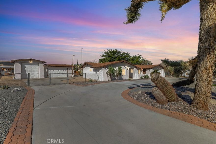Welcome to 6938 La Habra Avenue in Yucca Valley, a beautifully updated three-bedroom, two-bathroom home offering both comfort and versatility. This property features fresh exterior paint with a lifetime transferable warranty, and is powered as an all-electric home with a solar lease at only $130 per month. The roof is in good condition and approximately five years old, while the newly landscaped front yard showcases clean desert rock for easy maintenance. A large circular driveway provides convenience, along with RV and trailer parking. In addition to the attached two-car garage, there is an impressive detached three-car garage/shop of approximately 1,200 square feet (40x30) that includes an office and bathroom, and is tall enough to accommodate a small RV. Inside, the home has new interior paint throughout, radiant ceiling heat, and a wood-burning stove for cozy desert nights. The primary bedroom features a walk-in closet, carpet that has been professionally steam-cleaned, and a private bath with a stand-up shower. The additional bedrooms offer ceiling fans, tile flooring, and ample space. The kitchen, while in original condition, is exceptionally well-kept and functional. Other property features include dual storm windows, a covered front porch, a rear covered patio, a shed, mature shade trees including fruitless mulberry trees, and enormous epic Joshua Trees. There are laundry hookups for either propane or electric dryers. This home is well-located near shopping, dining, and public transportation, and sits just minutes from Joshua Tree National Park, offering endless hiking, climbing, and outdoor recreation. Yucca Valley also provides proximity to community parks, golf, local schools, and cultural attractions like the Hi-Desert Nature Museum and Joshua Tree’s renowned art and music scene.